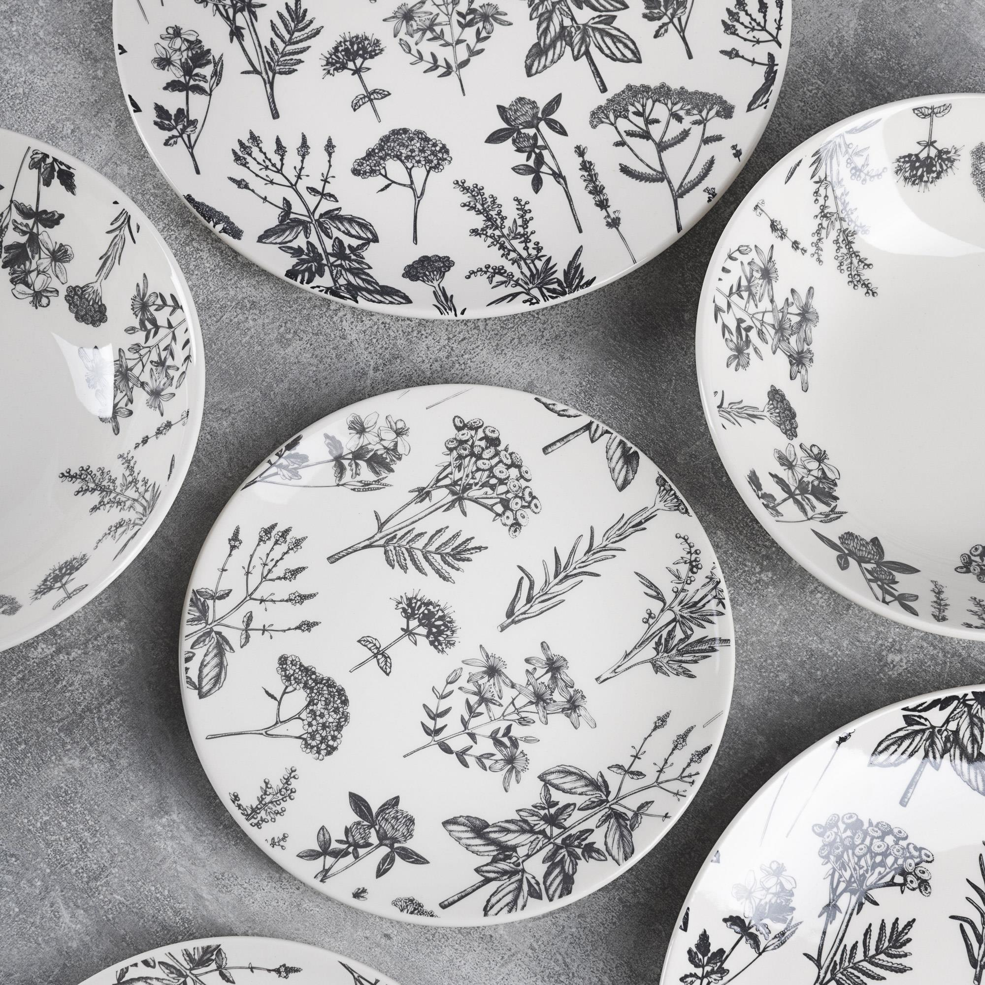 Platos blancos con ilustraciones botánicas negras de hierbas y flores.