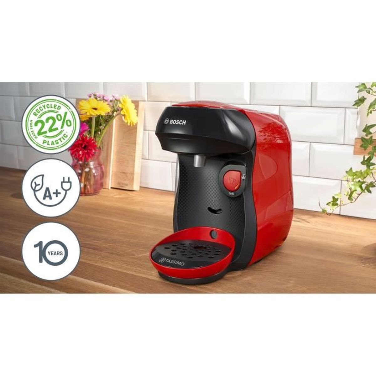 Macchina da caffè Bosch Tassimo rossa e nera su tavolo di legno con fiori.