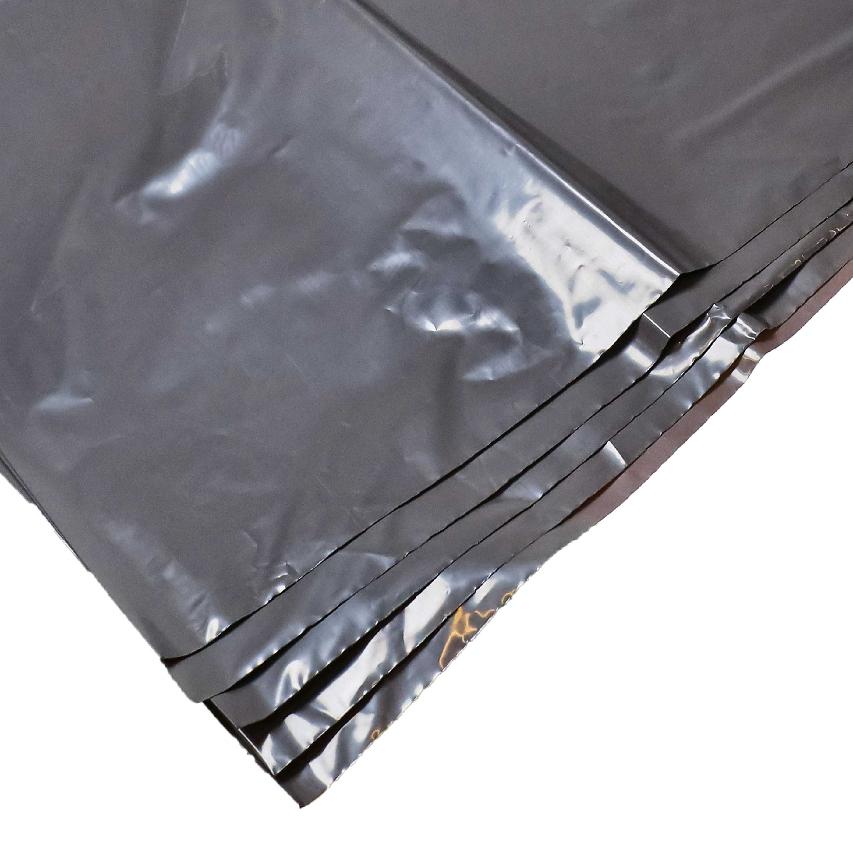 Stapel grauer, glänzender Plastiktüten mit Falten und Reflexionen.