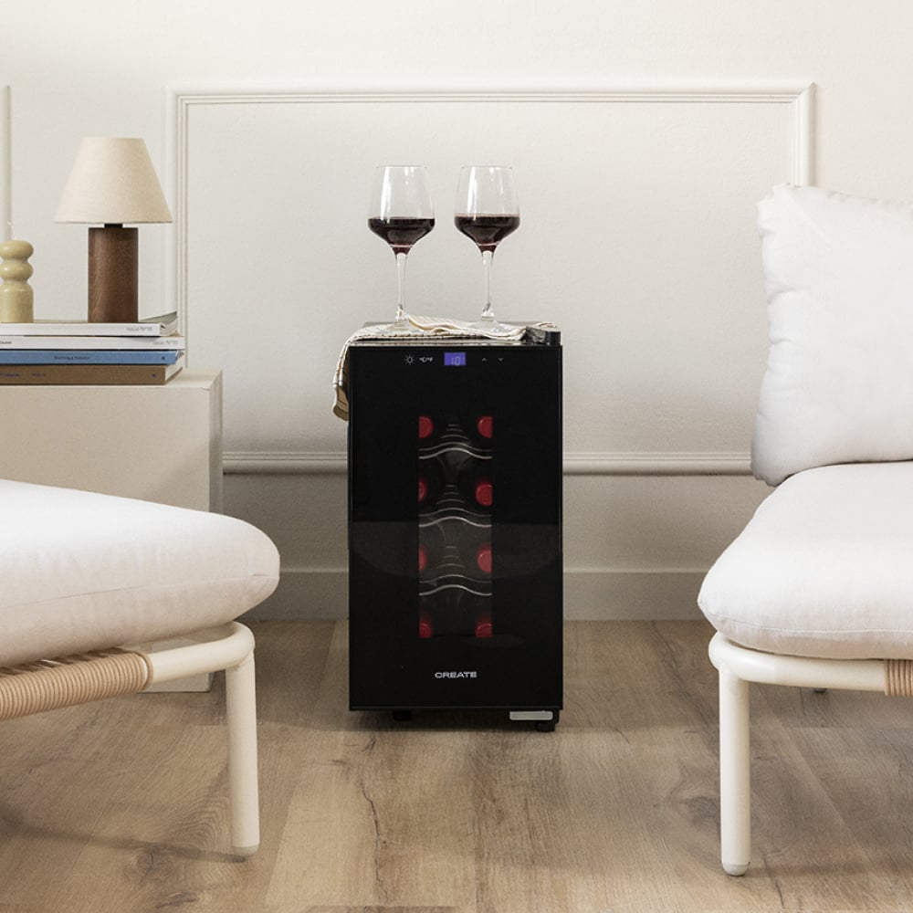 Una nevera de vino negra con dos copas de vino llenas de vino tinto encima.
