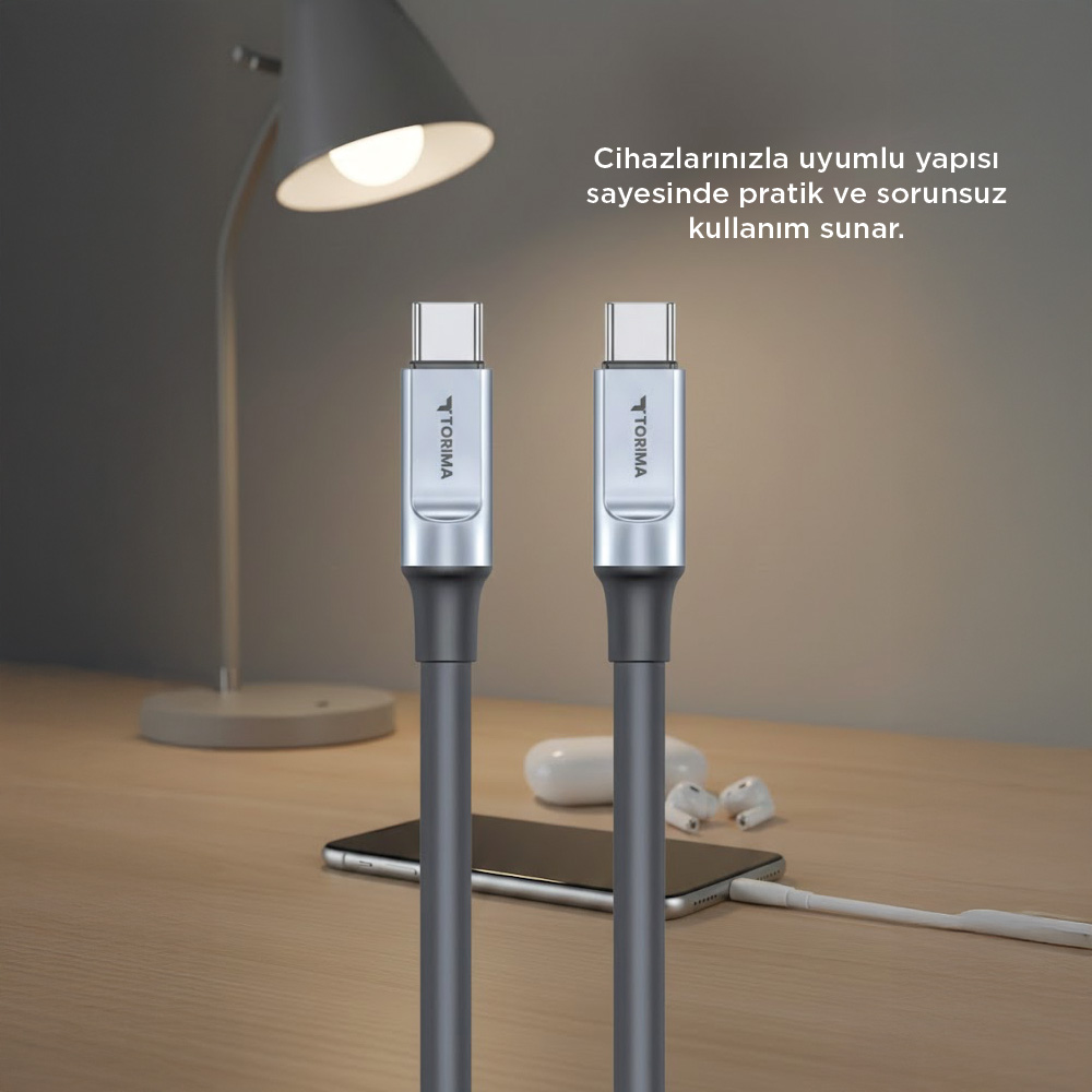 İki gri USB-C kablosu bir akıllı telefonun yanında masanın üzerinde duruyor.