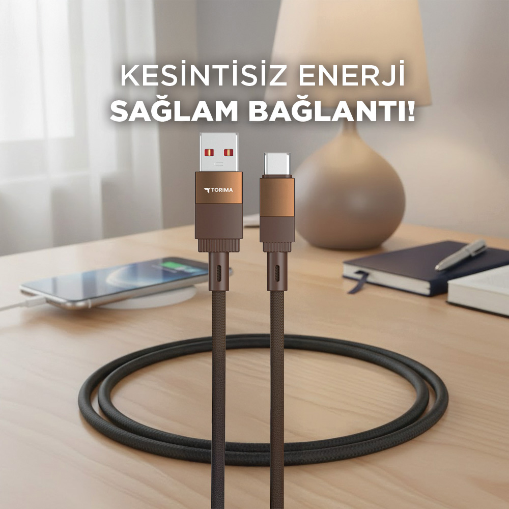 Ahşap bir masada USB-A ve USB-C kablosu. Bir telefon şarj oluyor.