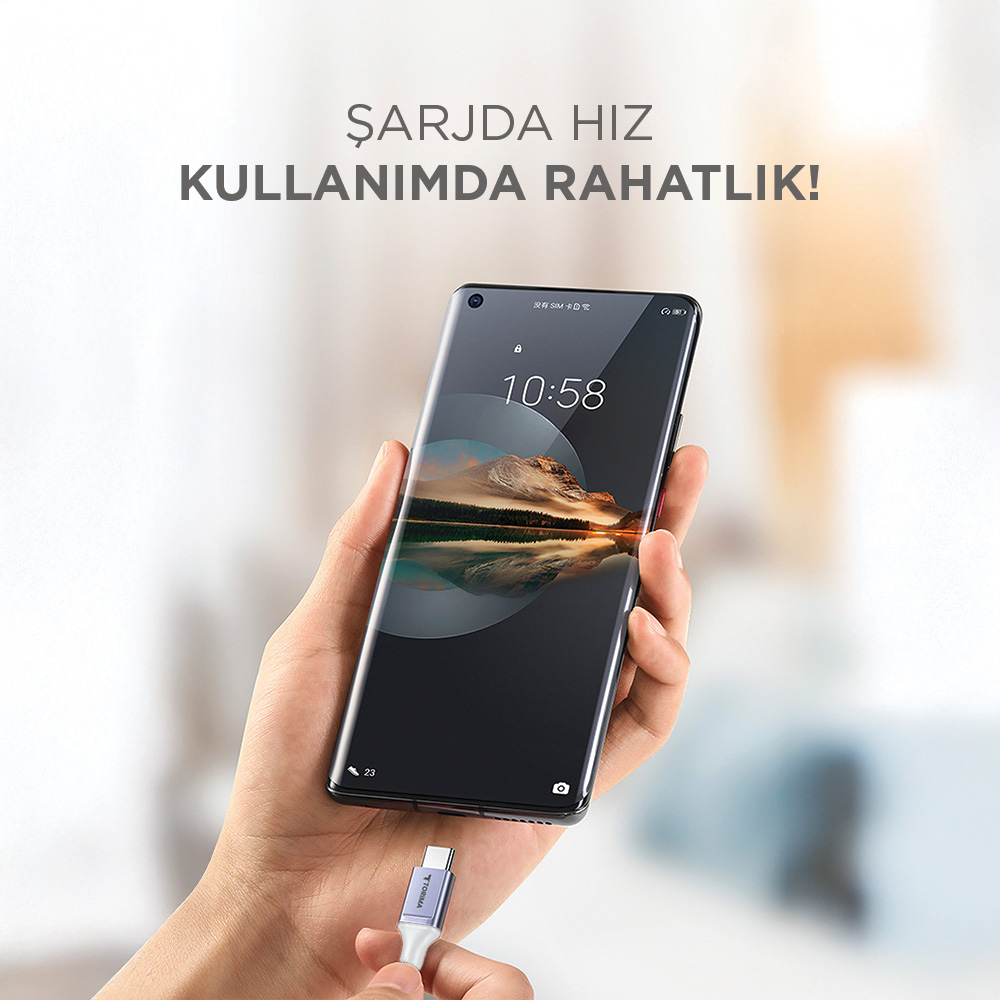 Bir el, şarj kablosuna bağlı bir akıllı telefon tutuyor.