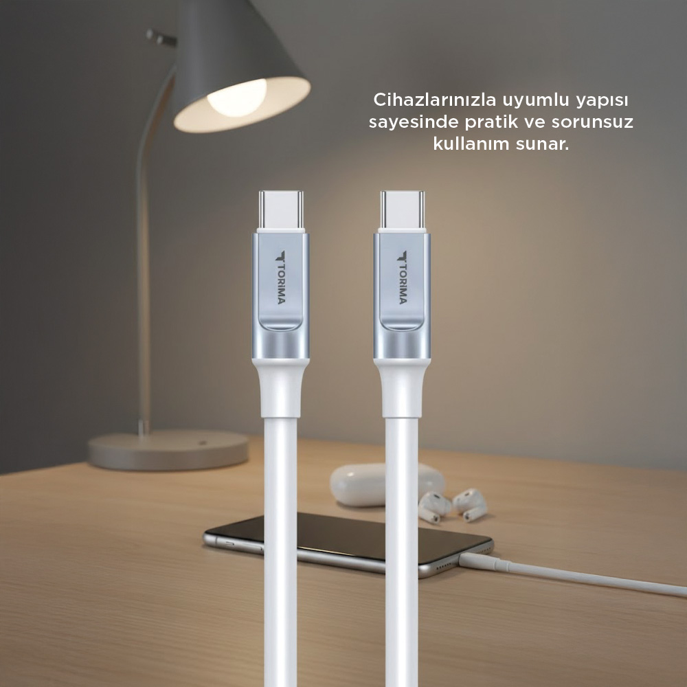 İki beyaz USB-C kablosu bir mobil telefonun yanında masada duruyor.