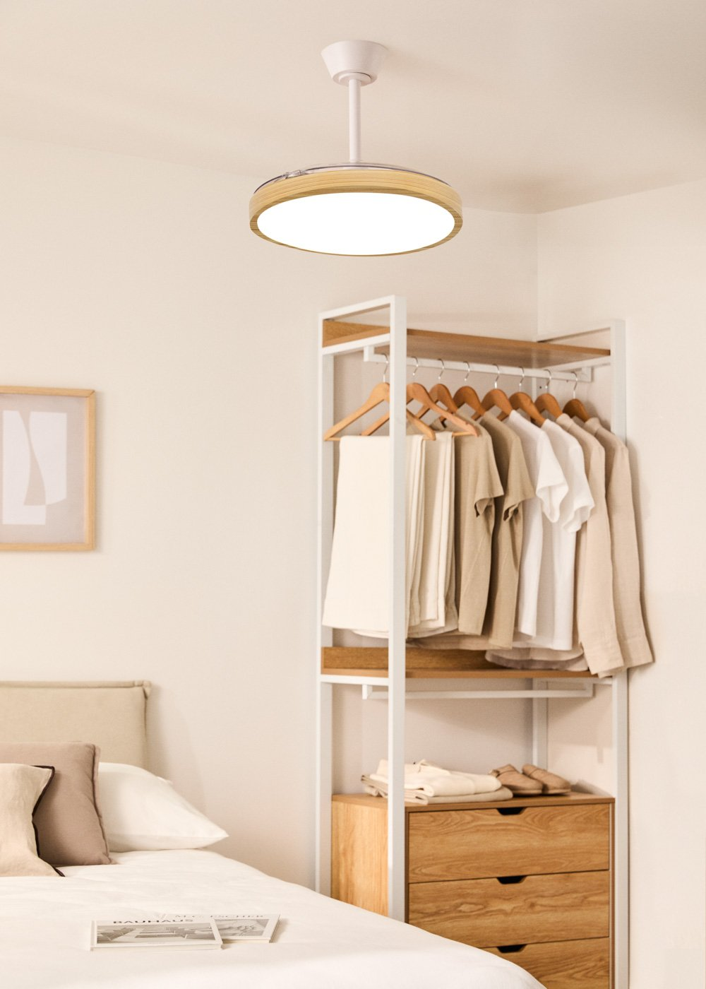Un dormitorio con perchero, cama y lámpara de techo.