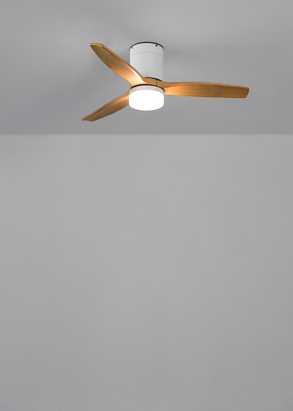 Un ventilador de techo moderno con tres aspas de madera y luz integrada.