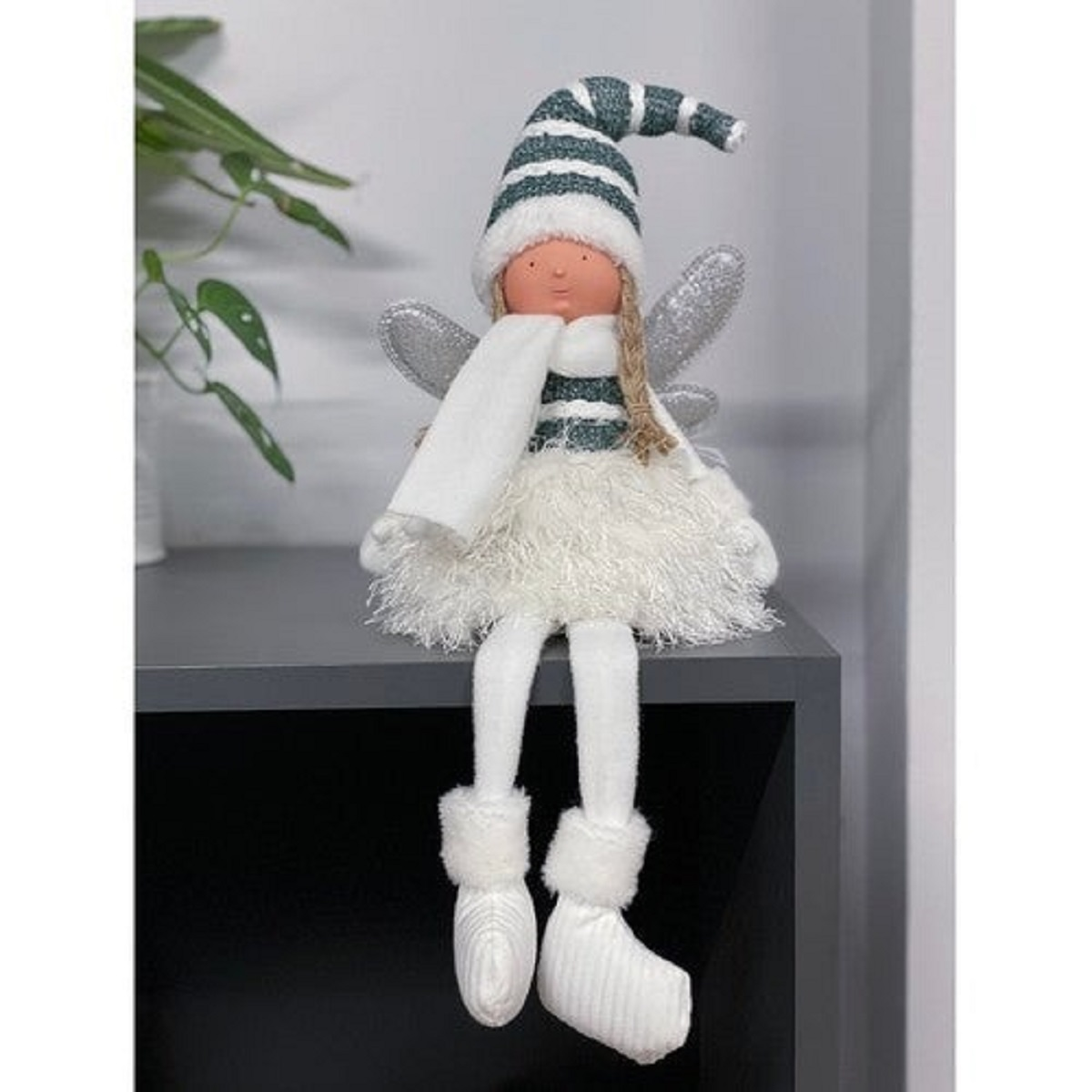 Una muñeca de hada de peluche con sombrero, bufanda y falda esponjosa.