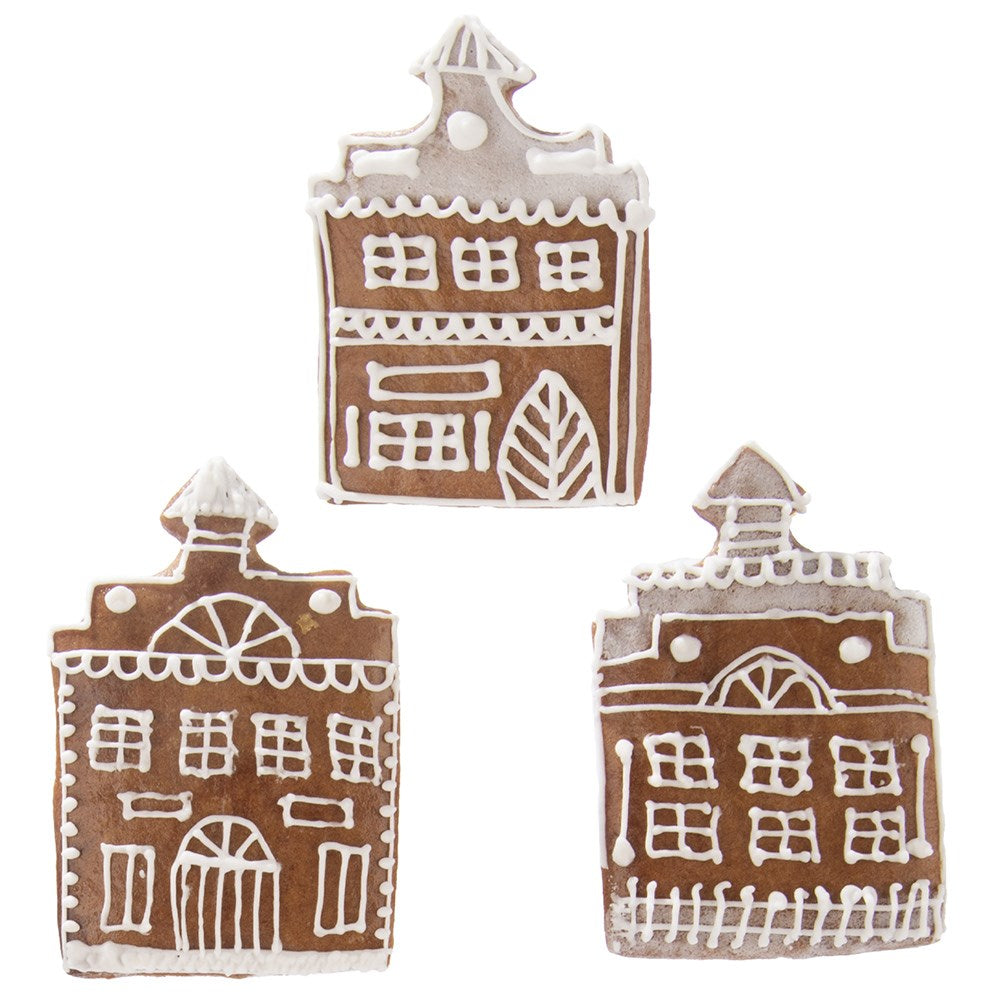 Tres casas de pan de jengibre decoradas con glaseado blanco.