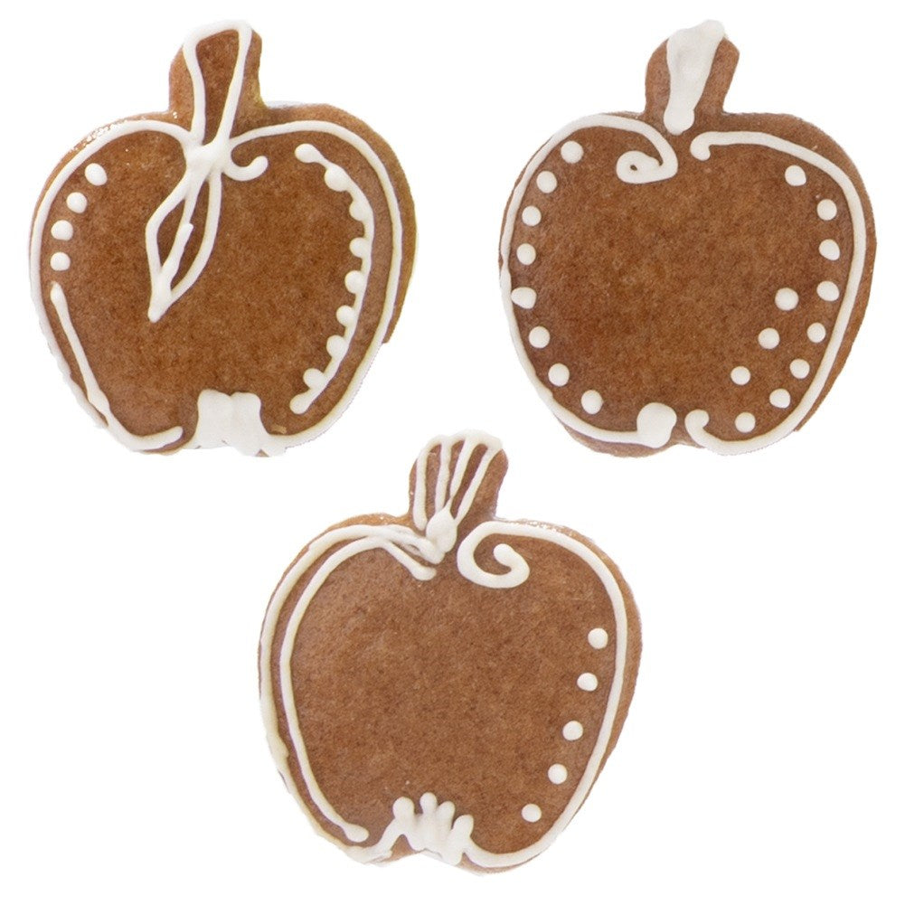 Tres galletas marrones con forma de manzana decoradas con glaseado blanco.