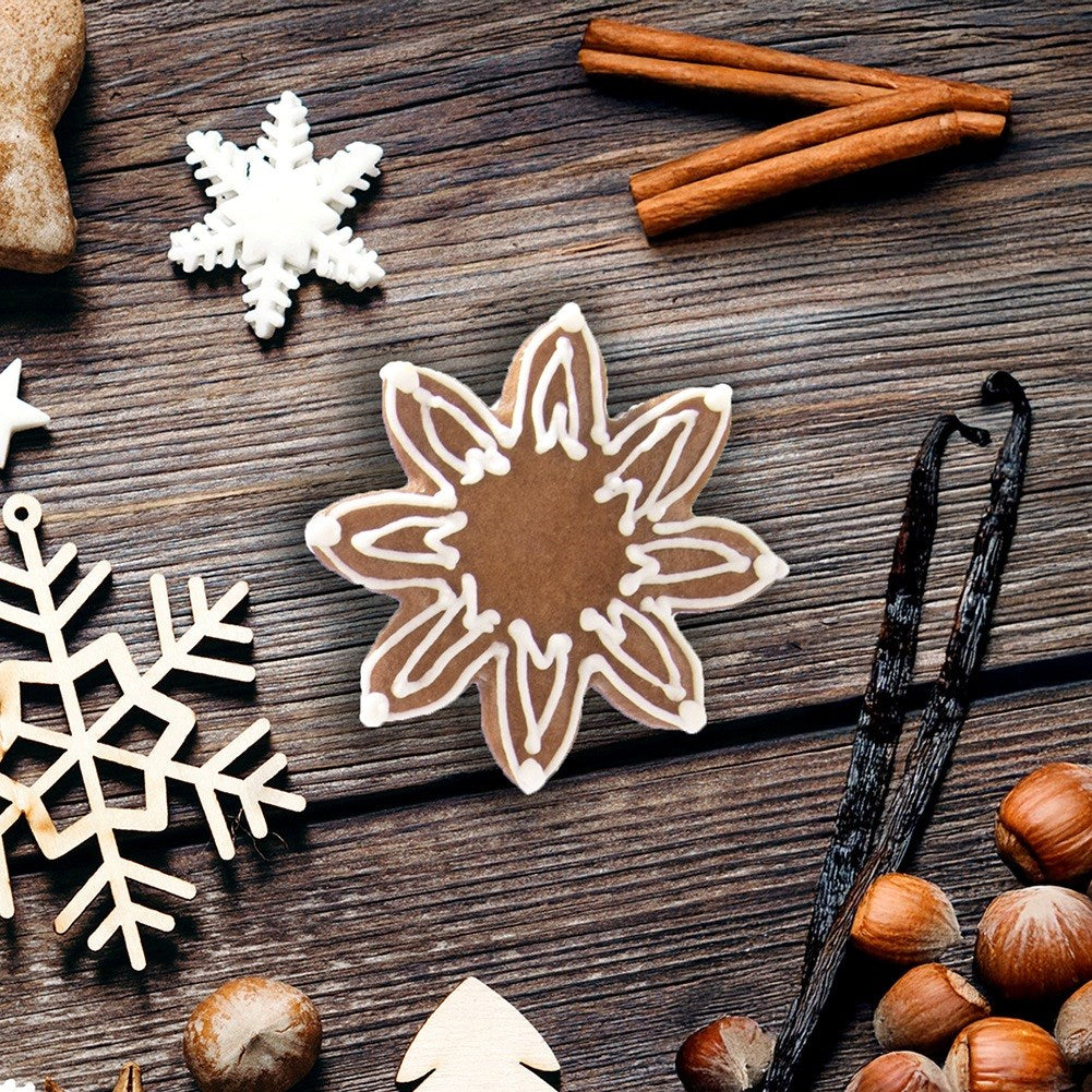 Galletas navideñas, canela, vainilla y avellanas sobre madera.