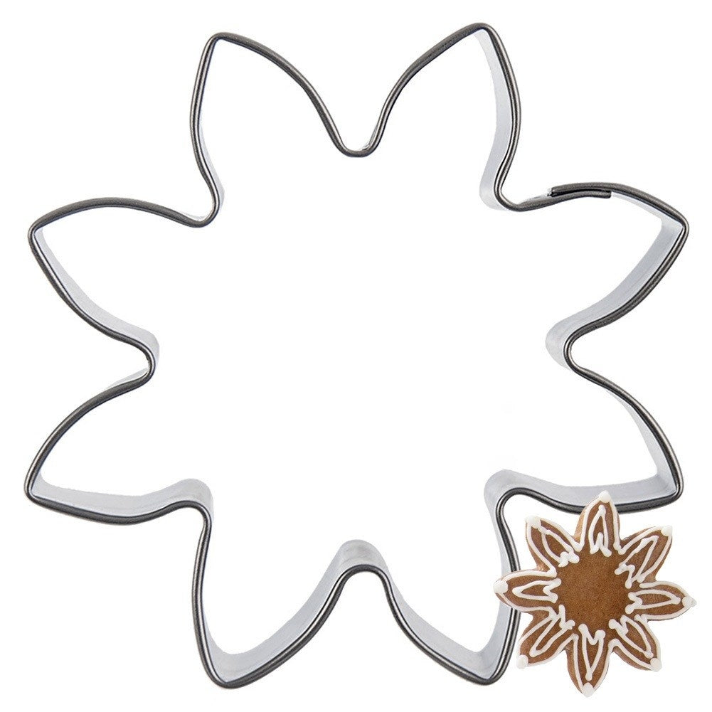 Un cortador de galletas en forma de estrella con una pequeña estrella de jengibre.