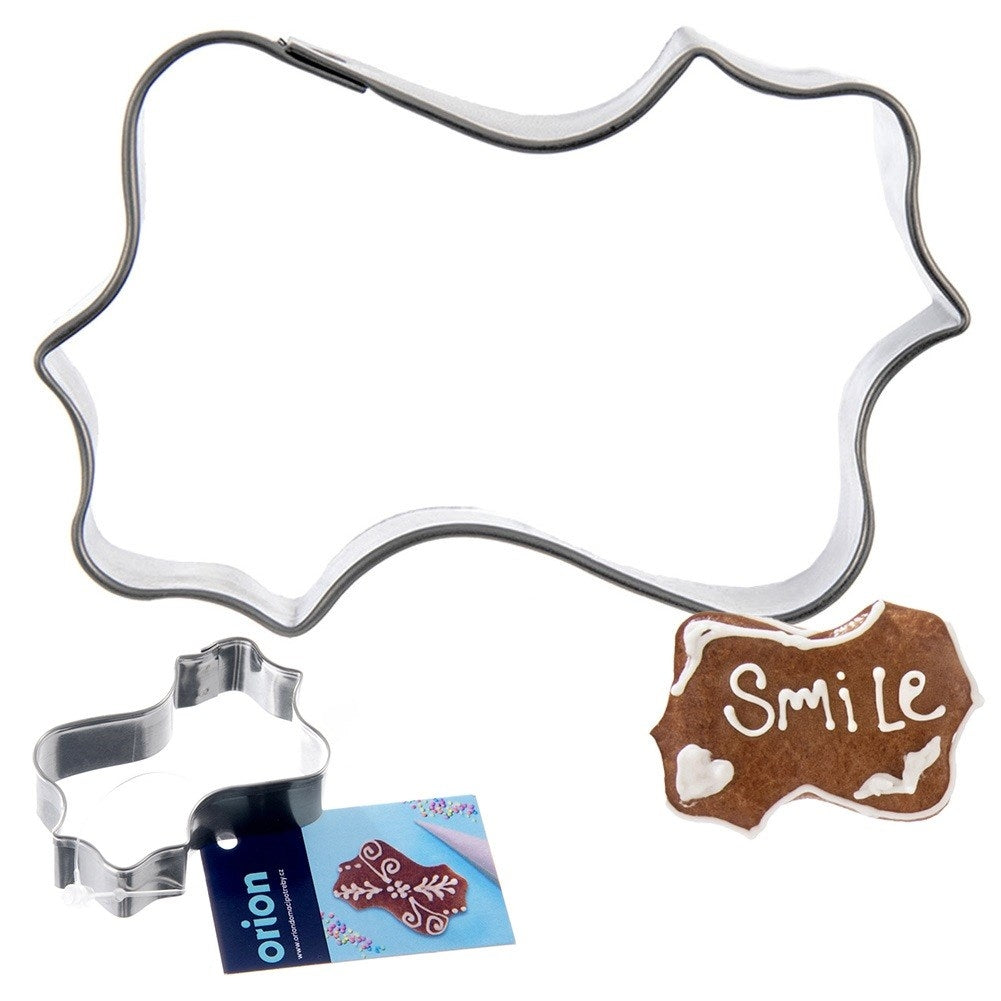 Cortador de galletas con forma de bocadillo junto a una galleta decorada con "Smile".