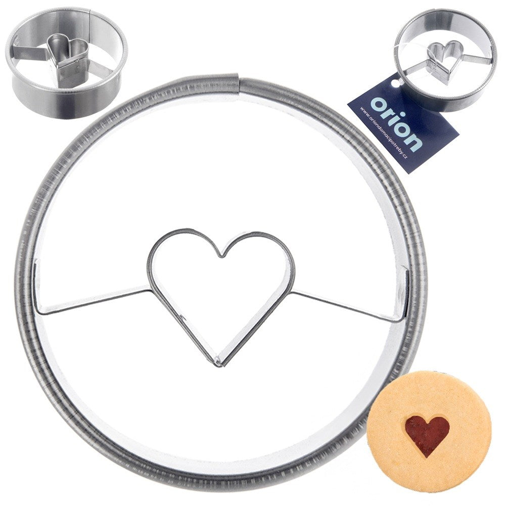 Cortador de galletas metálico con forma de corazón. Una galleta pequeña cortada con un corazón.