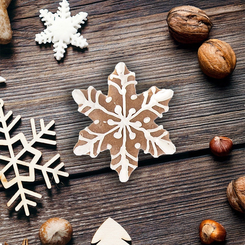 Galletas de copo de nieve, copos de nieve de madera y nueces sobre fondo de madera.