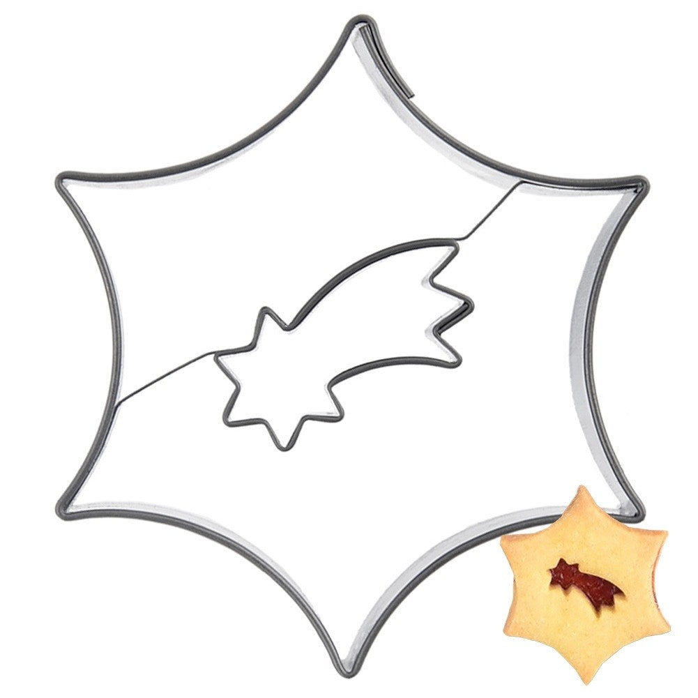 Cortador de galletas en forma de estrella con diseño de cometa. Una galleta al lado.