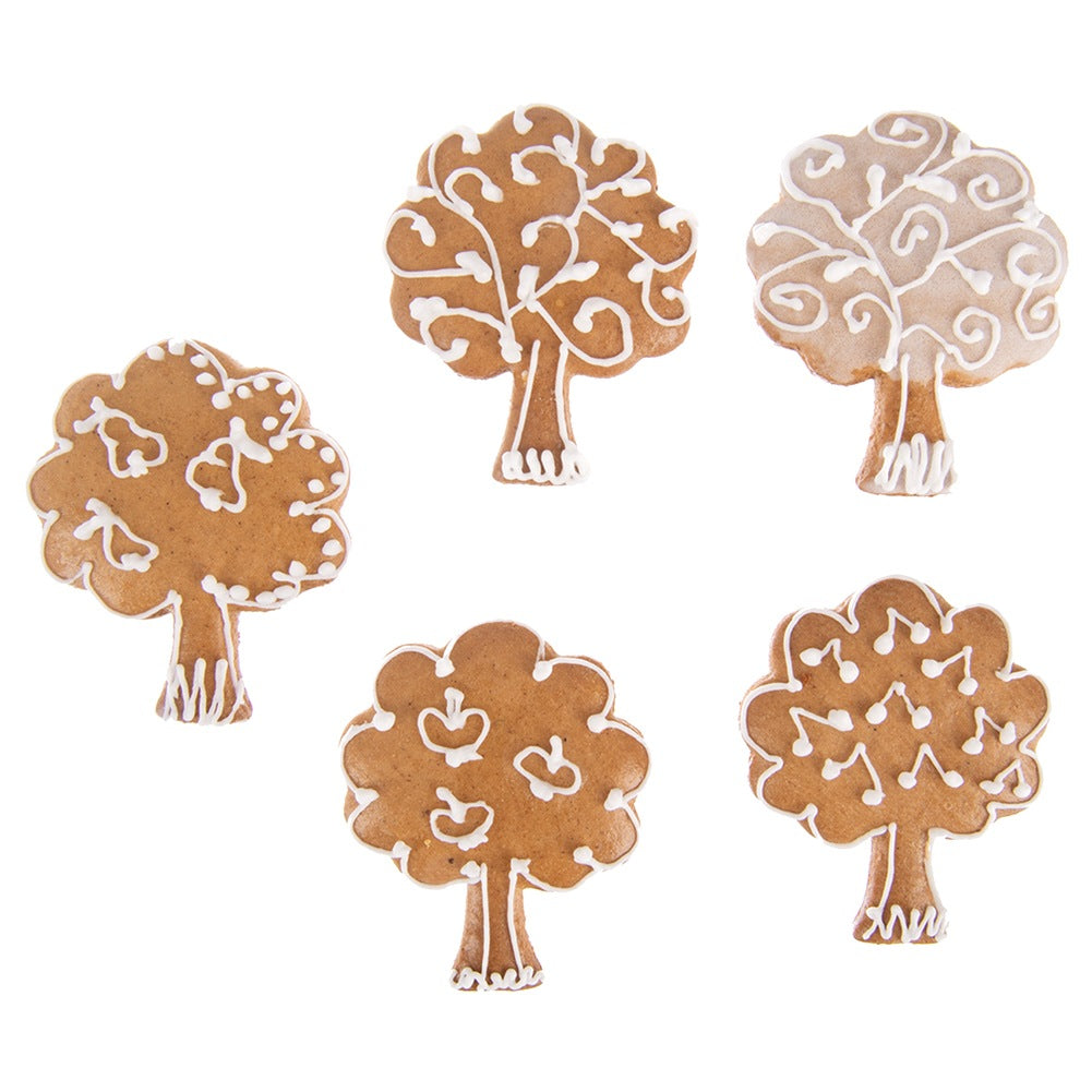 Cinco galletas de árbol de jengibre decoradas con glaseado blanco.