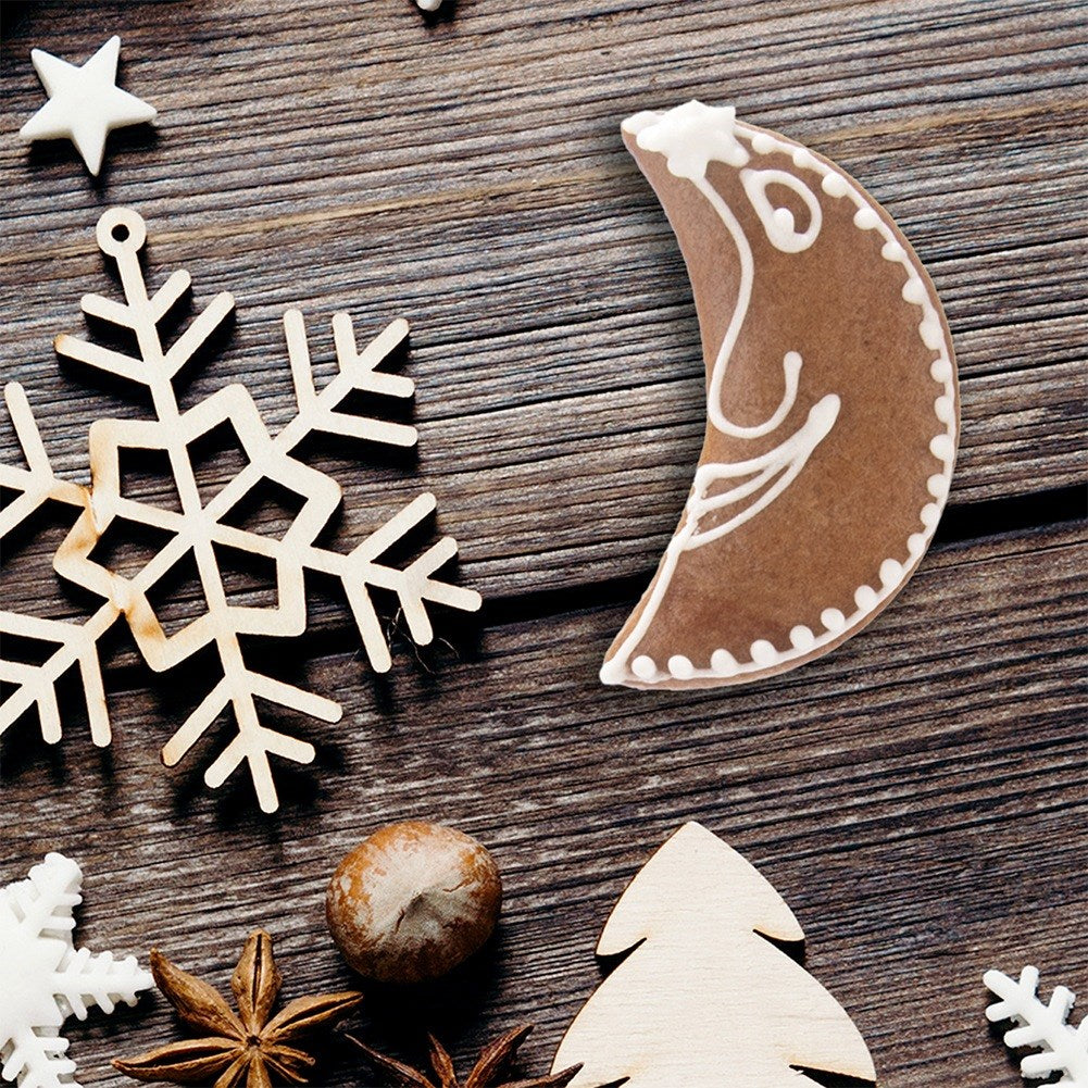 Decoraciones navideñas: luna de jengibre, copos de nieve de madera, anís estrellado, nuez, árbol.