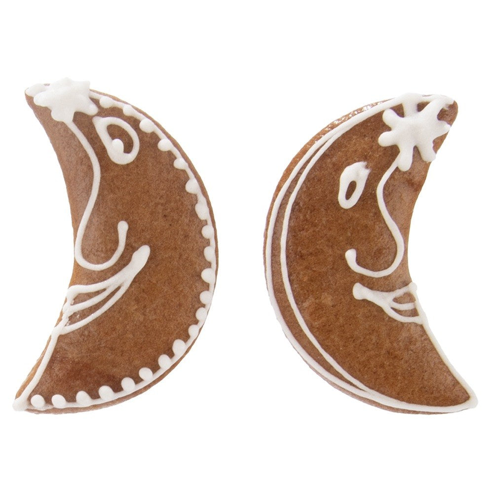 Dos galletas de luna creciente con caras de glaseado blanco y estrellas.