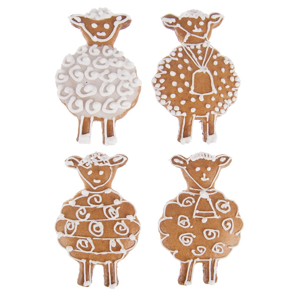 Cuatro galletas de jengibre con forma de oveja decoradas con glaseado blanco.