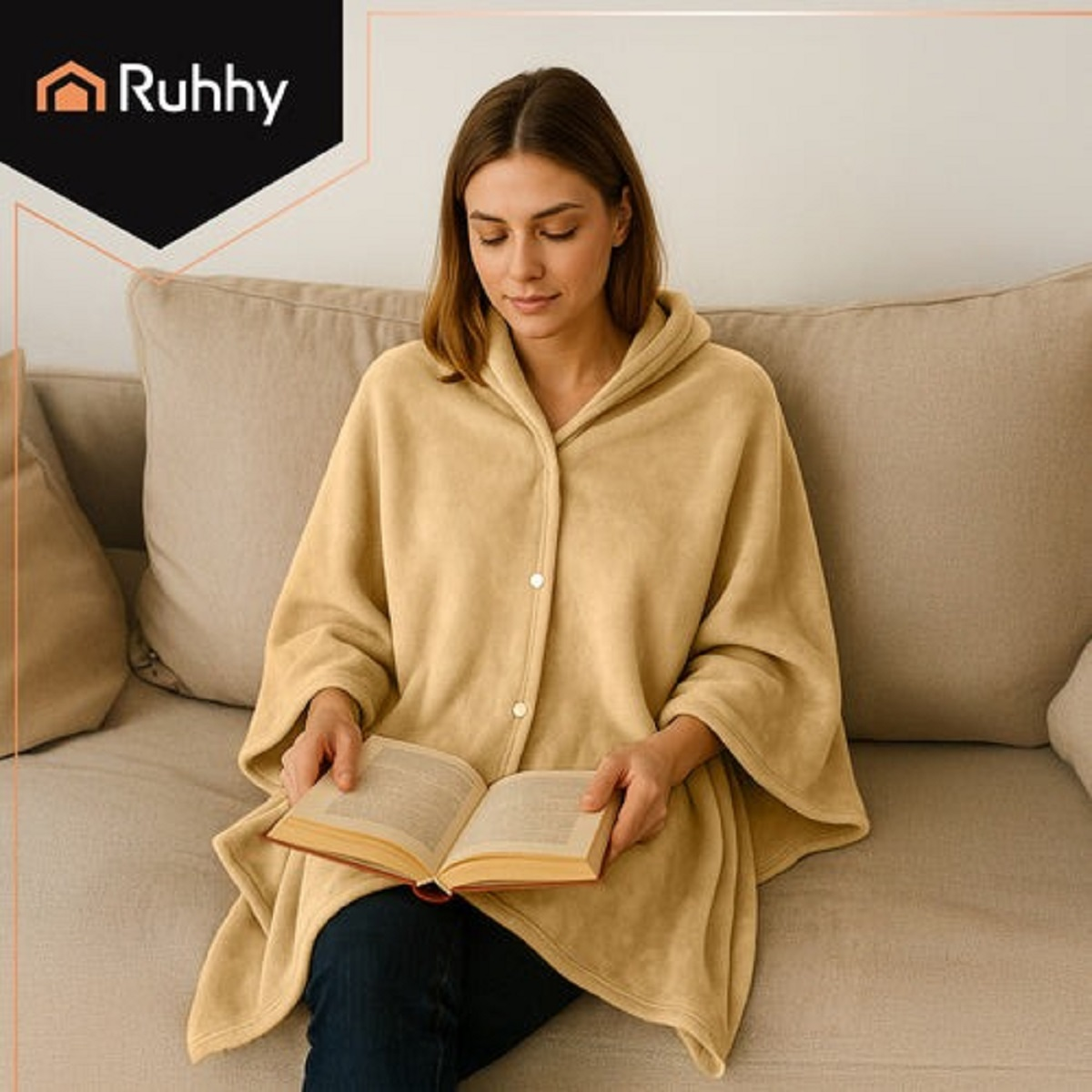 Una mujer sentada en un sofá leyendo un libro, vestida con una capa amarilla.