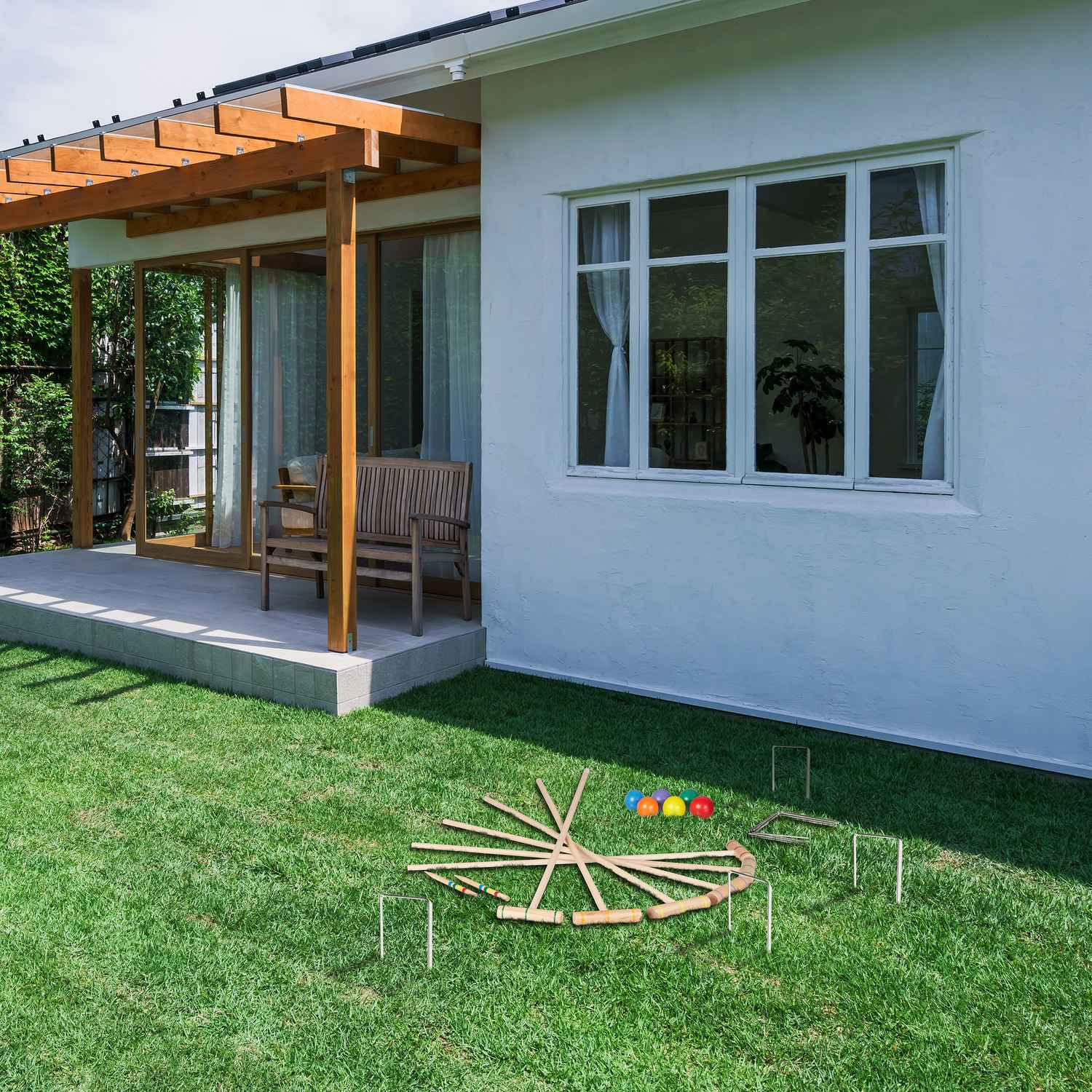 Jardín trasero con césped y un juego de croquet, pelotas y arcos.
