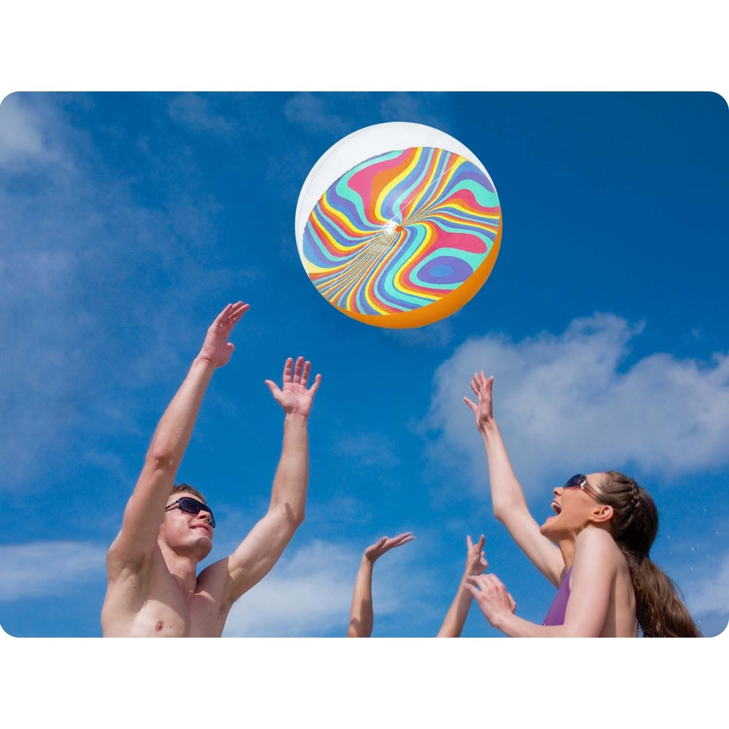 Gente alcanzando una pelota de playa colorida contra un cielo azul con nubes.