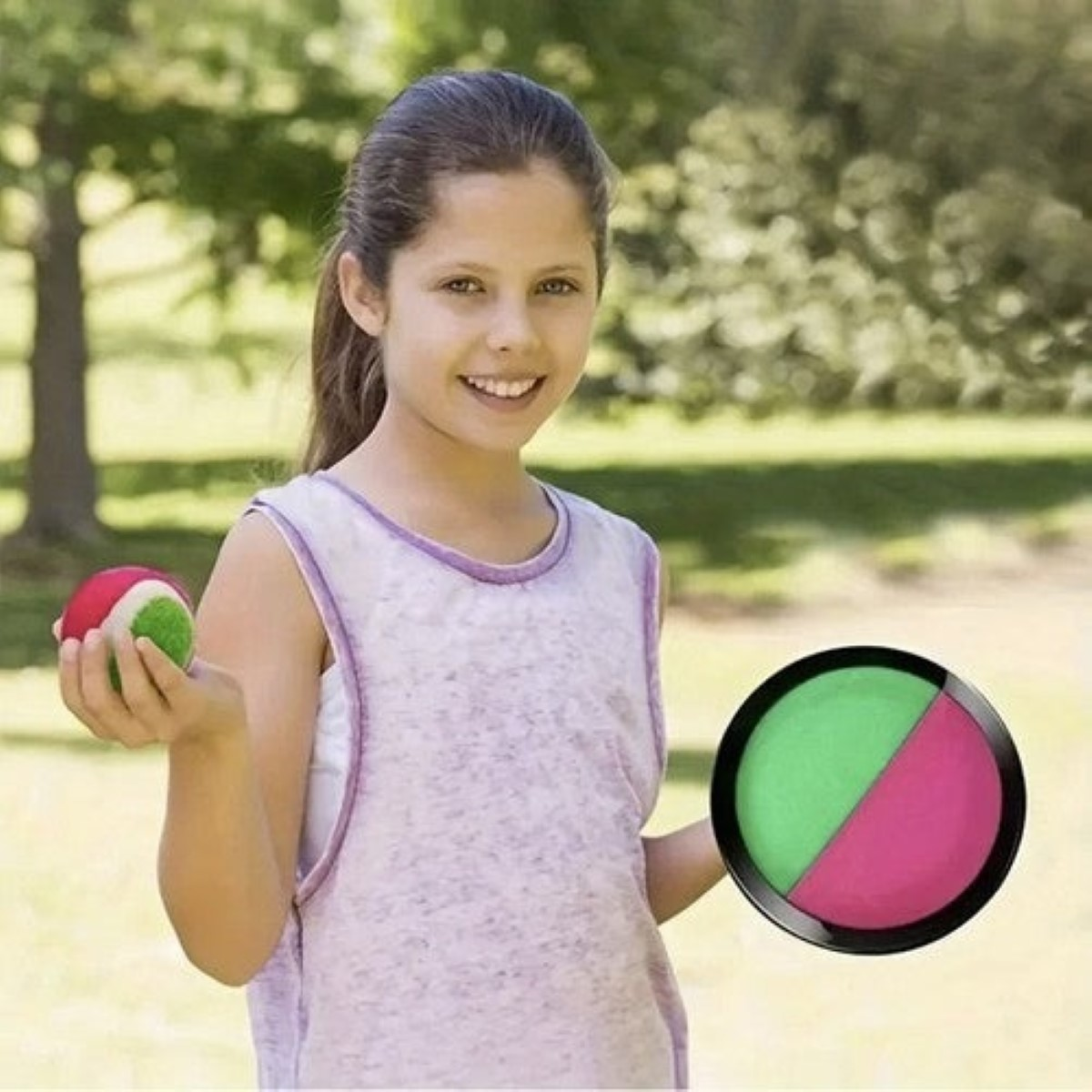 Una niña sostiene una pelota. Otra pelota descansa cerca.