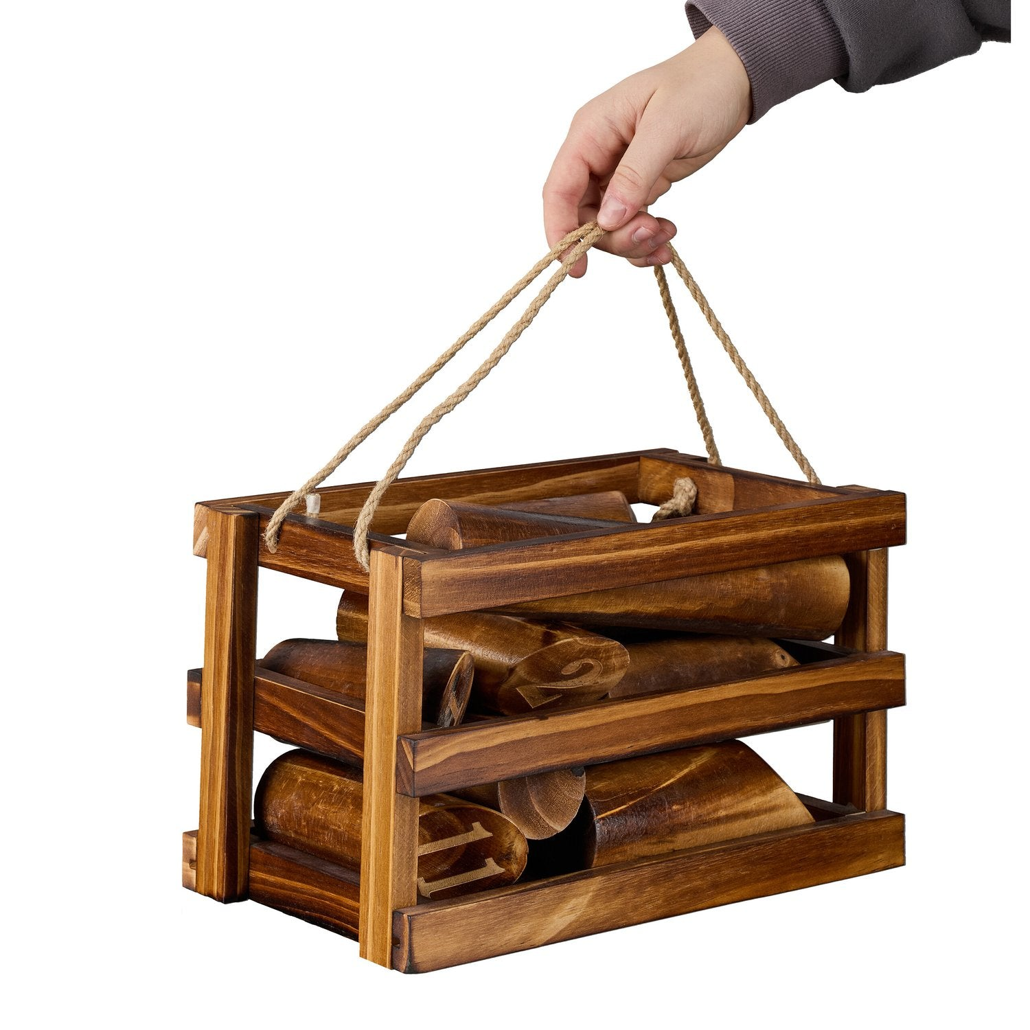 Una mano levanta una caja de madera llena de troncos con asas de cuerda.