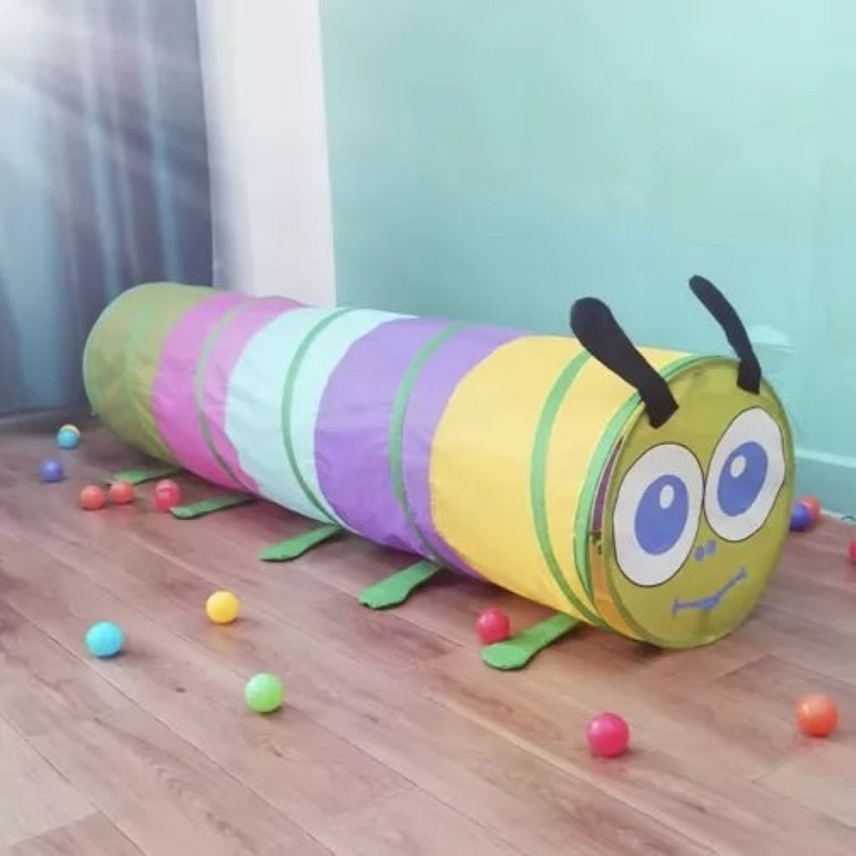 Un túnel de gateo colorido con forma de oruga en el suelo.