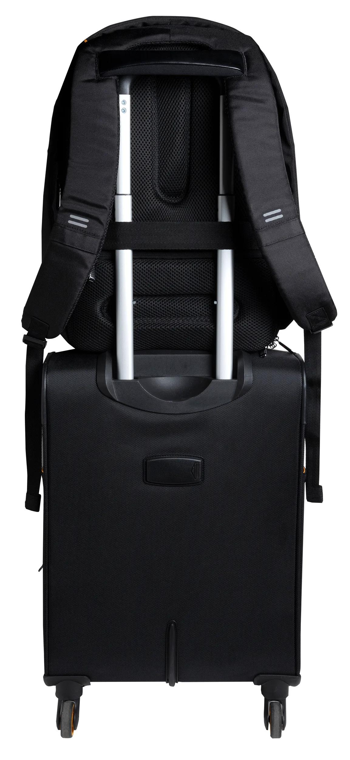 Mochila negra sobre una maleta de ruedas negra con asas plateadas.