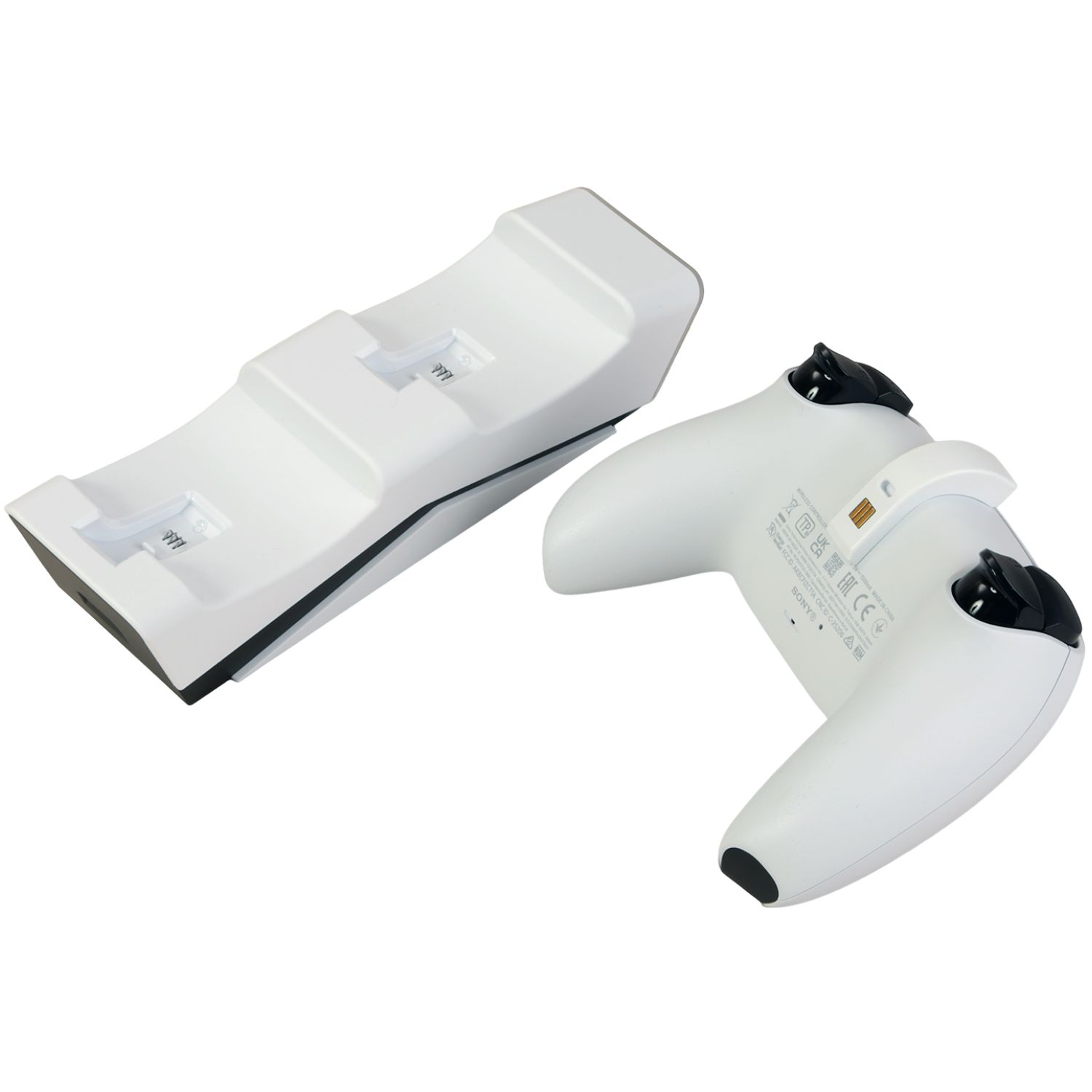 Ein weißes Controller-Ladegerät und ein weißer Controller liegen nebeneinander.