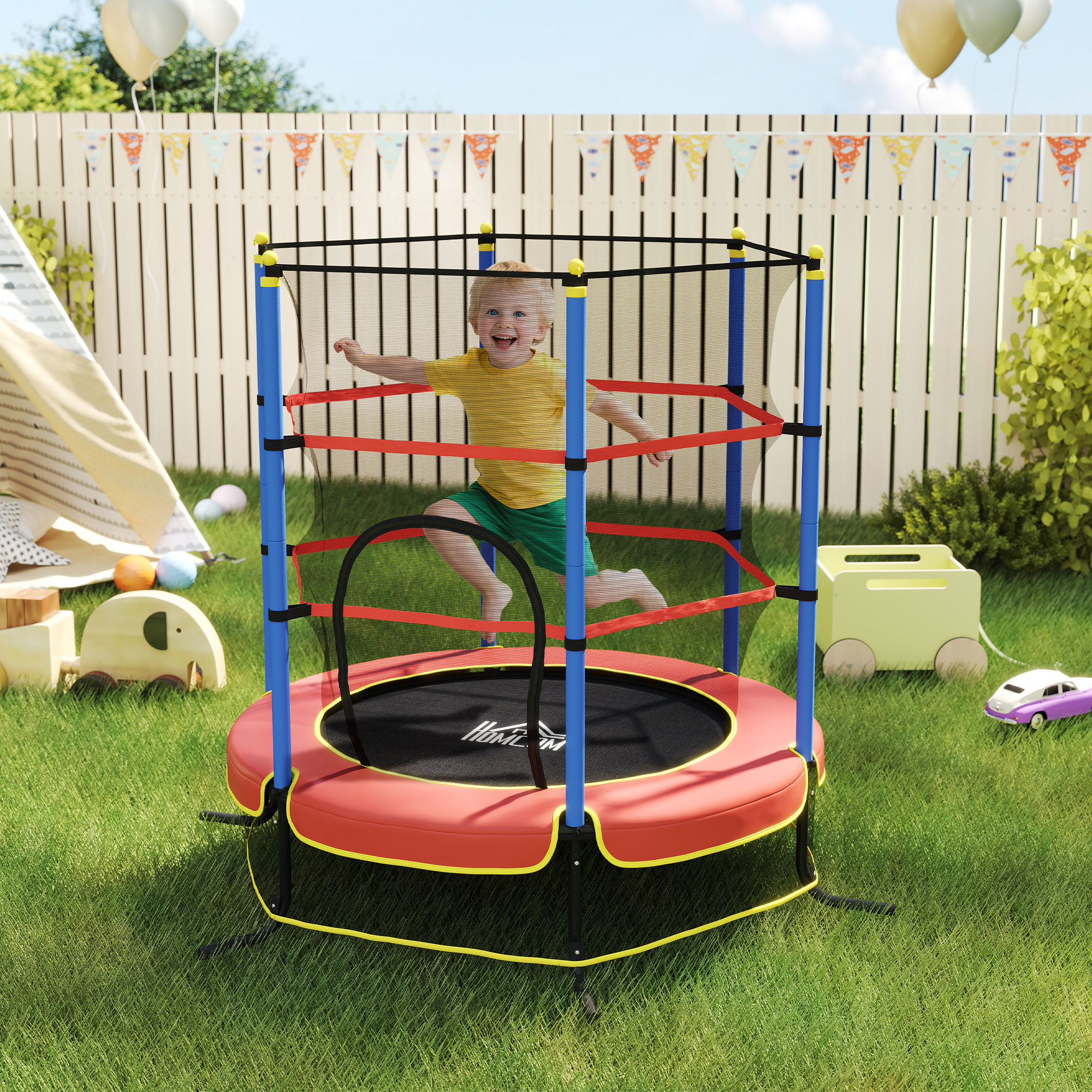 Un bambino felice salta su un trampolino in giardino. Giocattoli sull'erba.