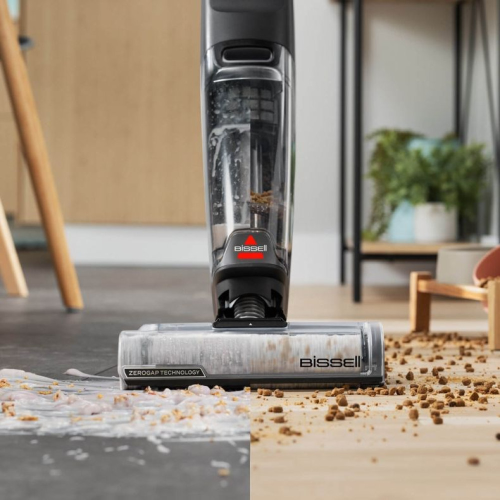 Czyścik do podłóg z przezroczystym zbiornikiem na brudnej podłodze z zanieczyszczeniami i płynem.