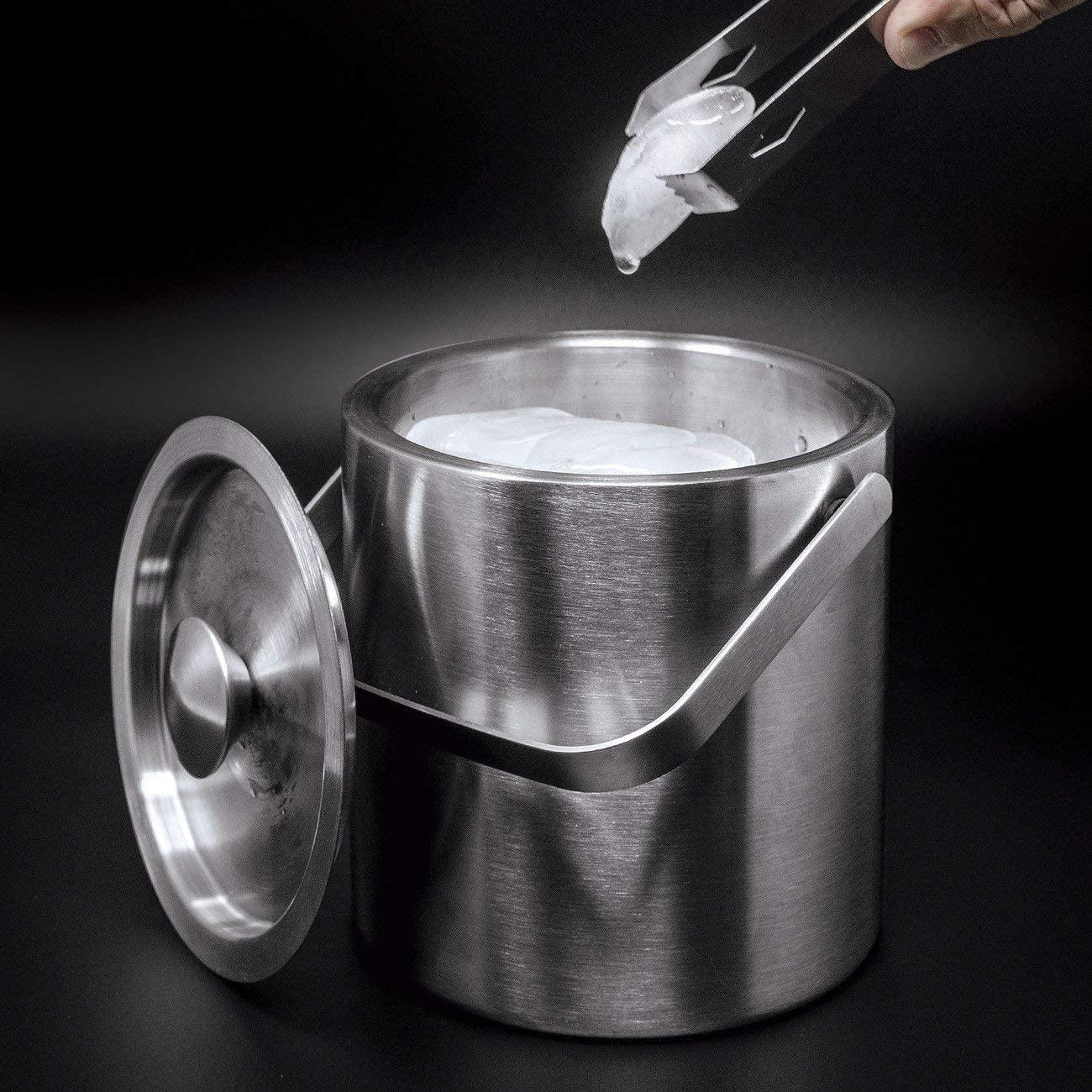 Eiswürfel werden mit einer Zange aus einem Metall-Eiskübel entnommen.