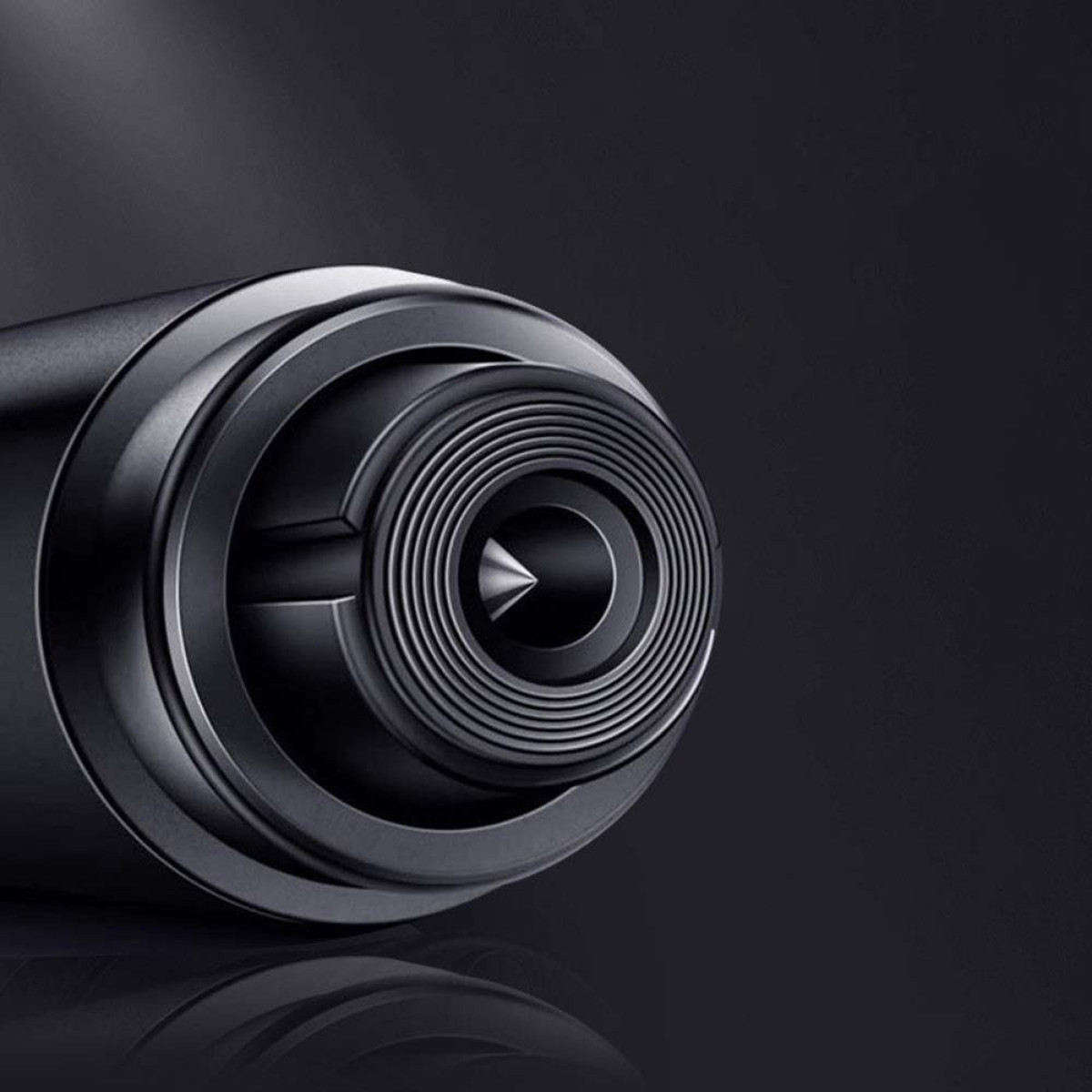 Zbliżenie ciemnego, metalowego obiektu z koncentrycznymi pierścieniami i ostrym końcem.