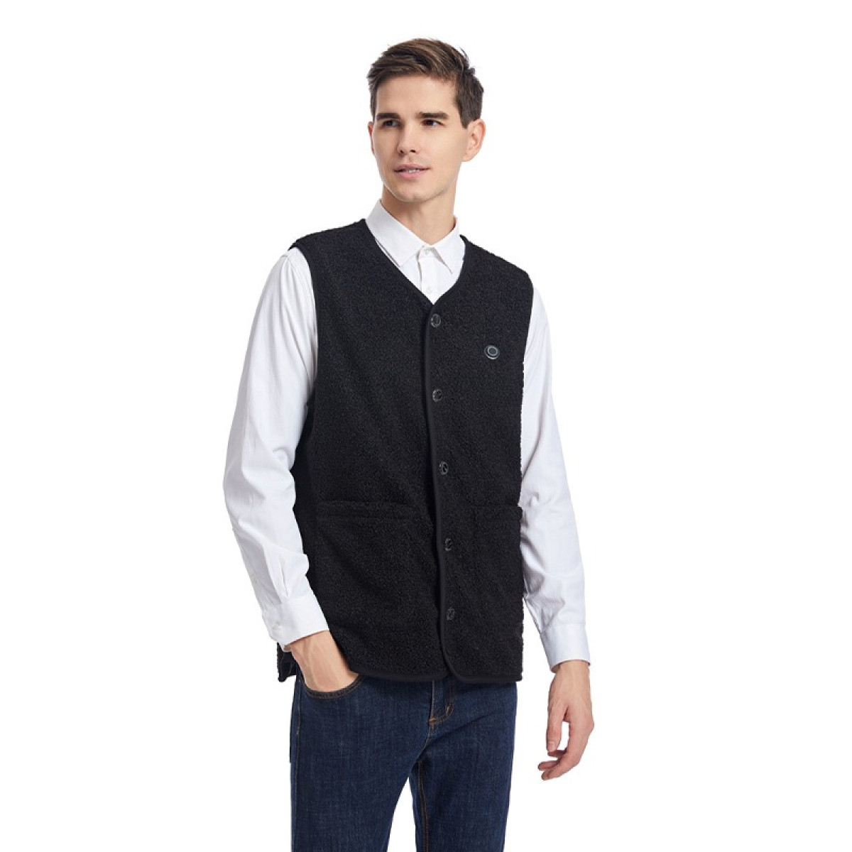 Mężczyzna w czarnej kamizelce sherpa na białej koszuli i dżinsach.