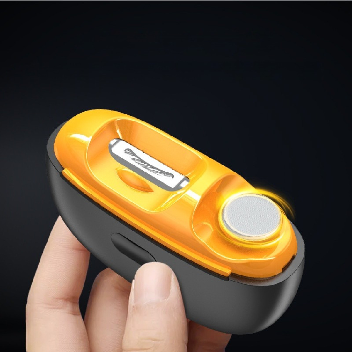 Dłoń trzyma pomarańczowo-czarną ostrzałkę do ołówków z srebrnym ostrzem.