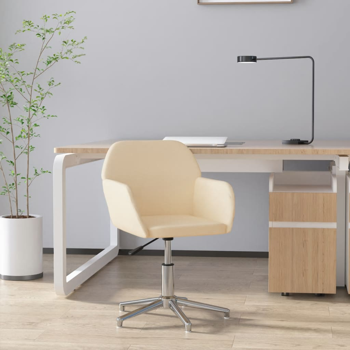 Ein beiger Bürostuhl steht vor einem Schreibtisch mit einem Laptop und einer Lampe.