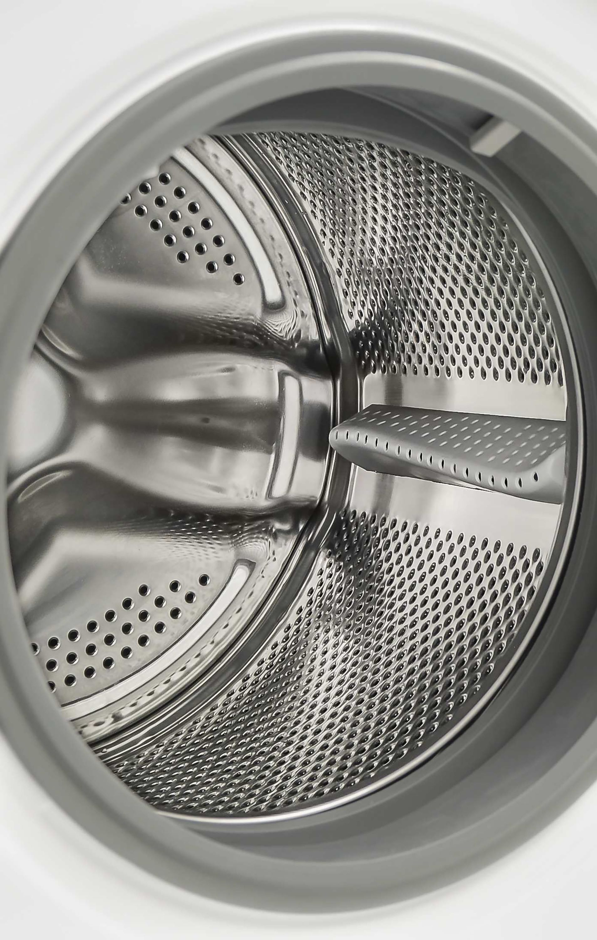 Innenansicht der Trommel einer Waschmaschine mit Metallstruktur und Löchern.