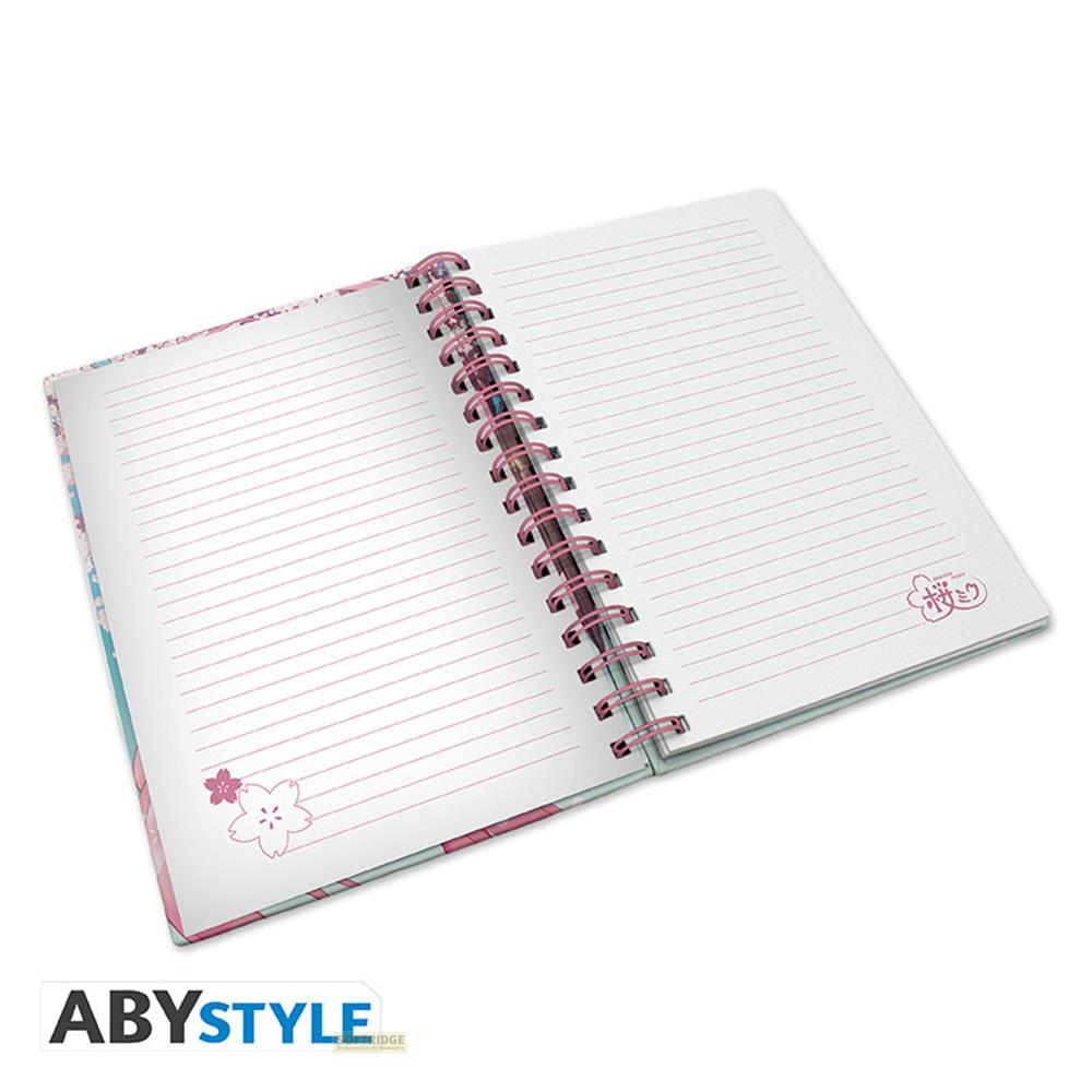 Offenes Notizbuch mit pinker Spiralbindung und linierten Seiten. Kirschblütendesign.