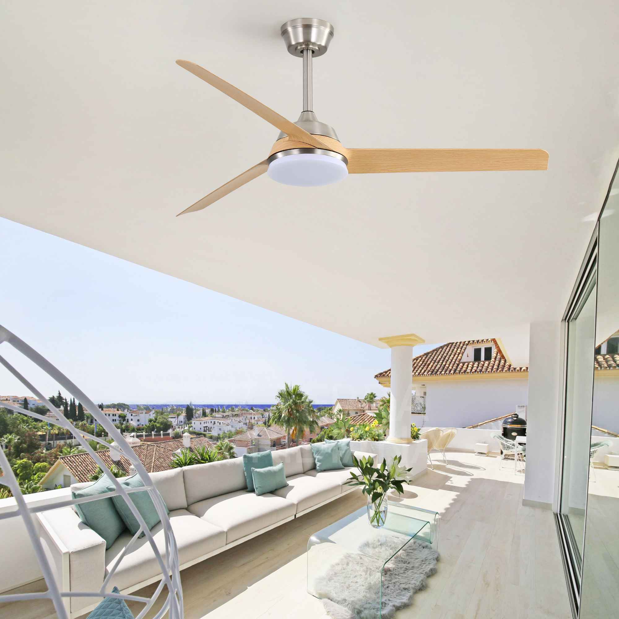 Deckenventilator mit Holzblättern über einer Couch auf einer Terrasse mit Meerblick.