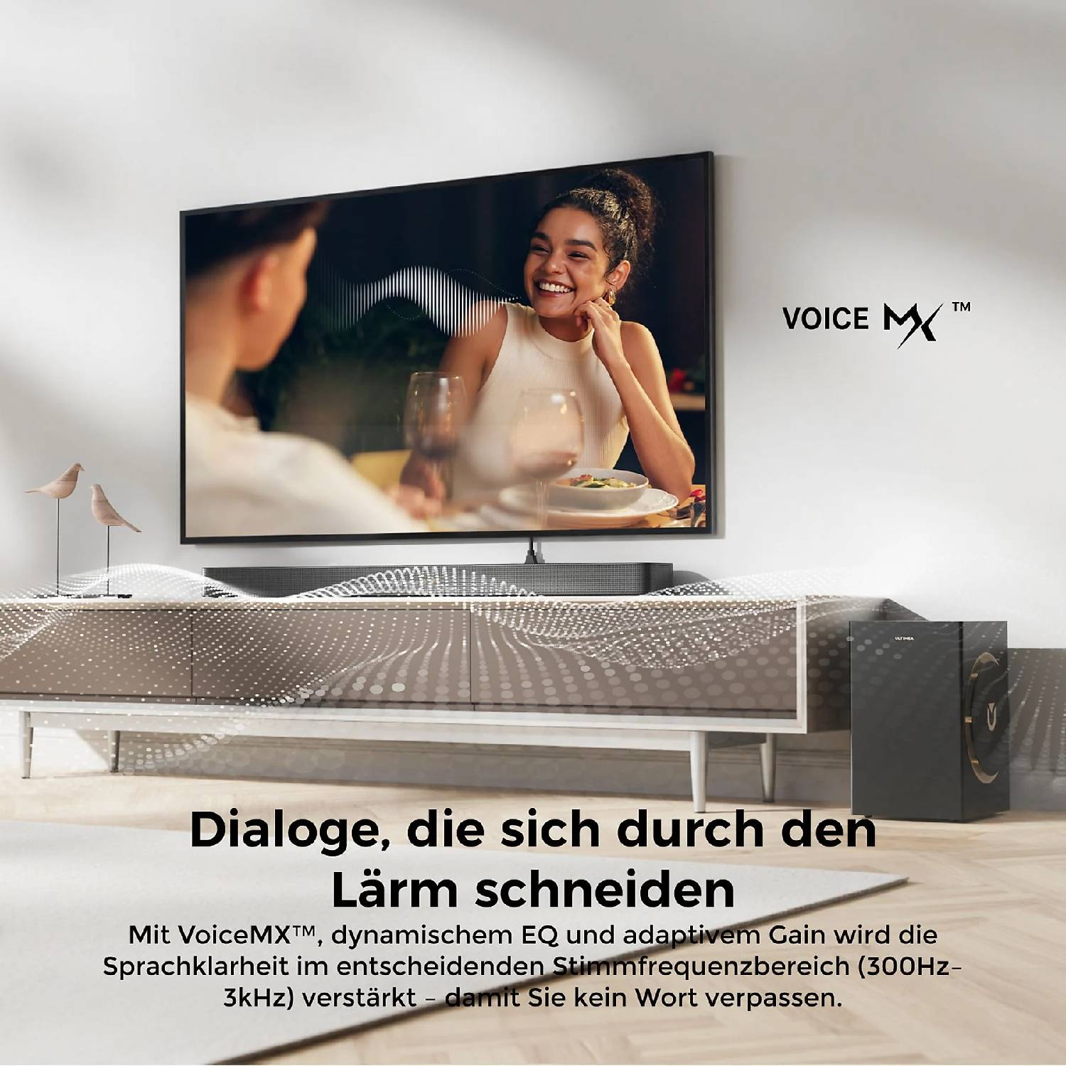 Une télévision montre un visage souriant, avec un subwoofer et du texte à proximité.
