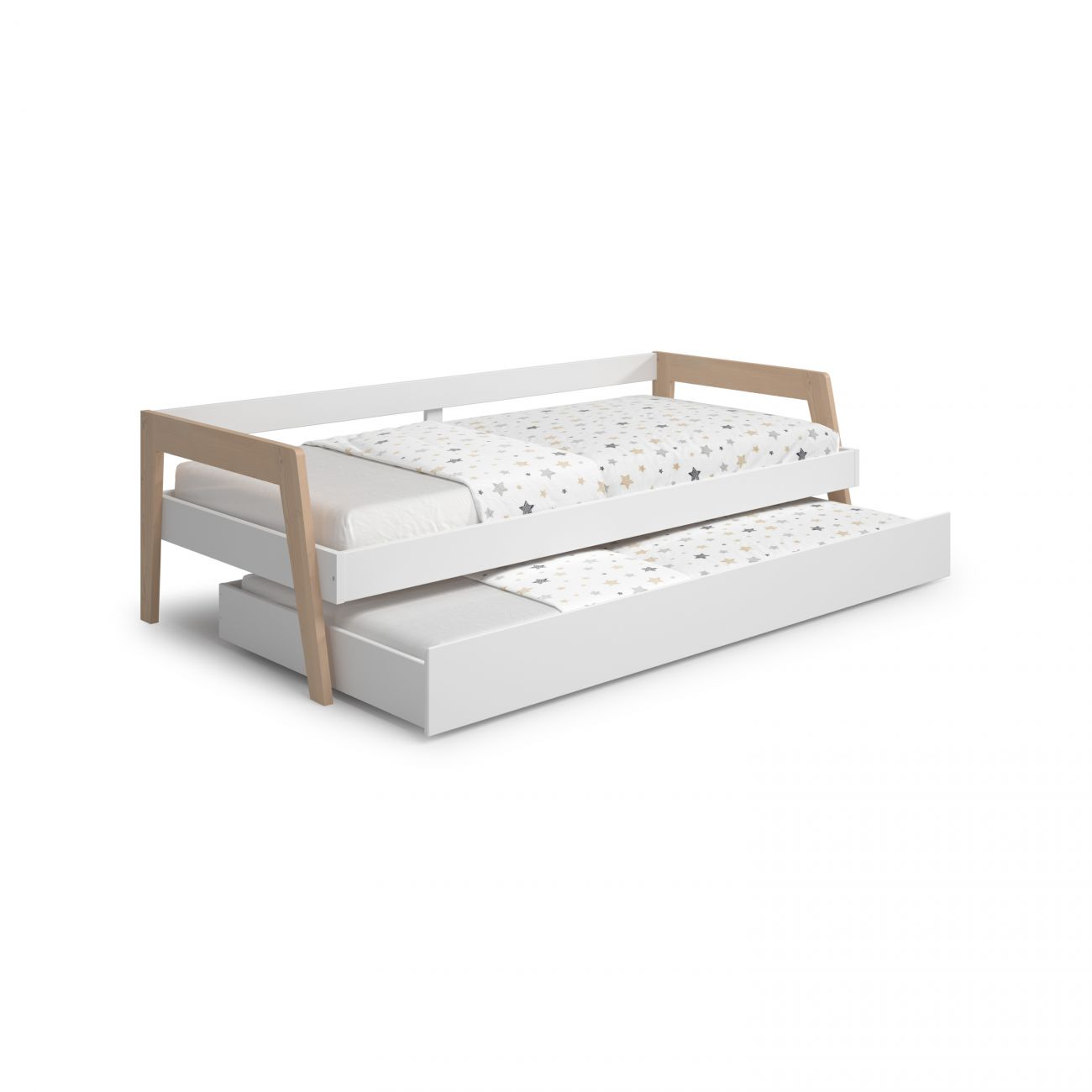 Cama blanca con nido extraíble, con ropa de cama estampada de estrellas.