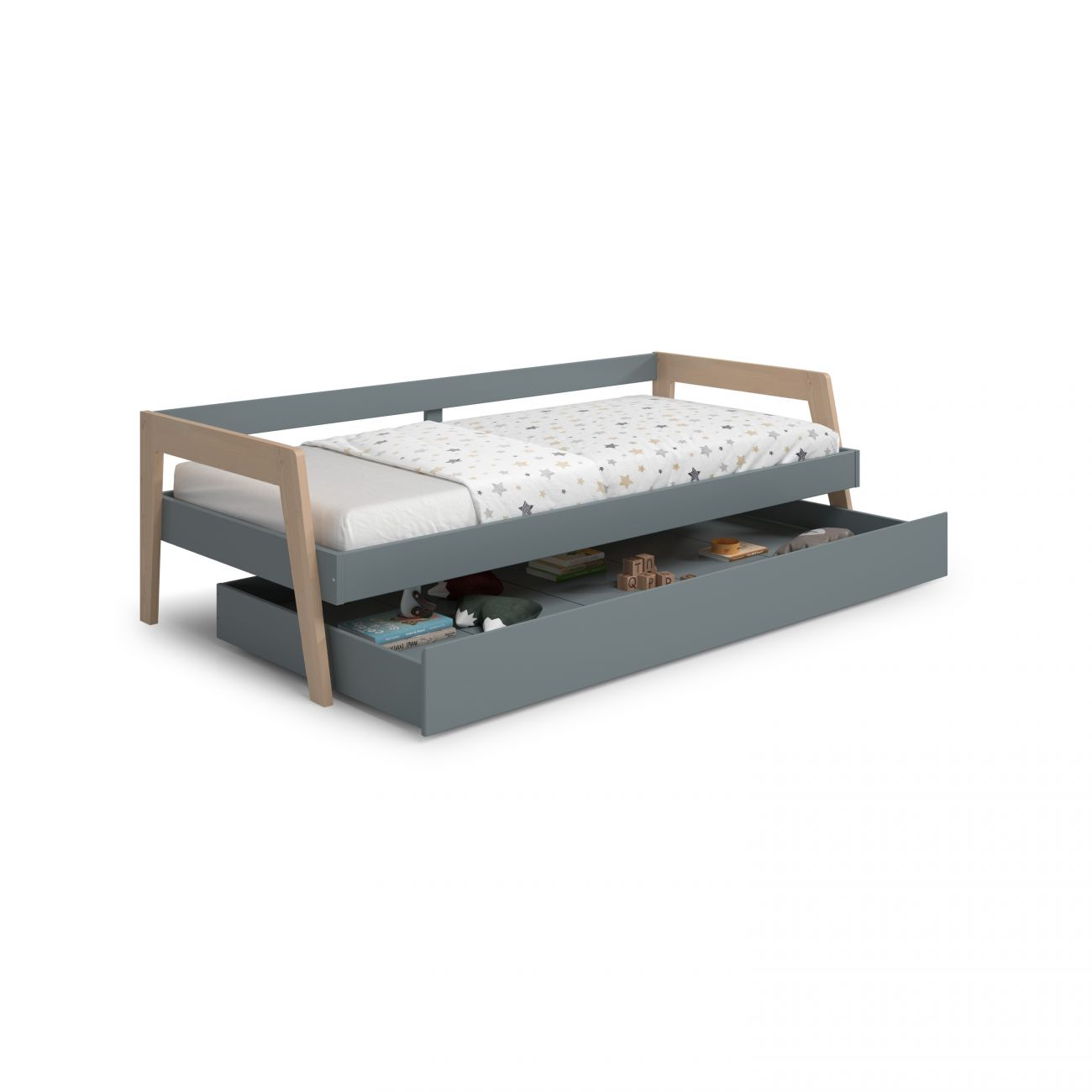 Cama infantil gris con cajón extraíble y edredón de estrellas.