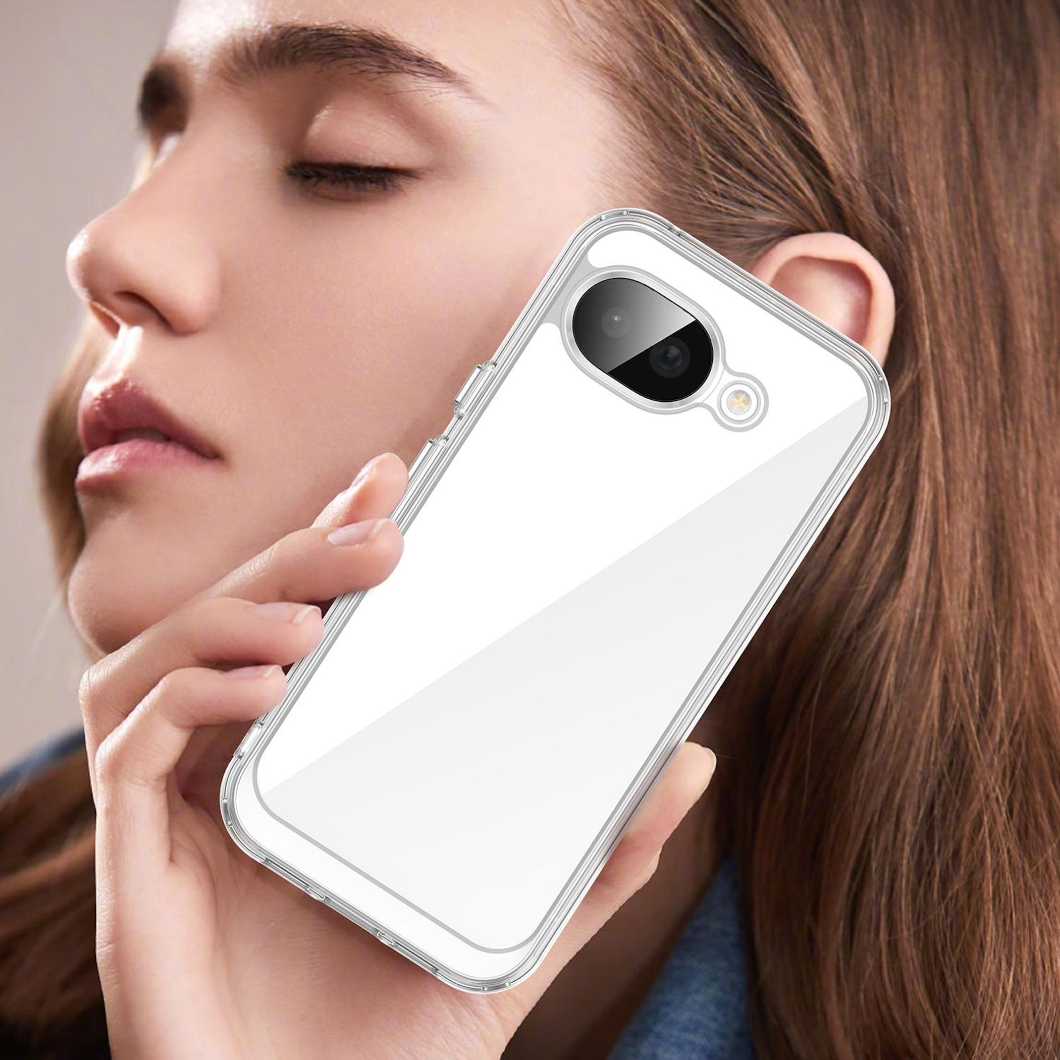 Eine Frau hält ein durchsichtiges Handy mit weißem Hintergrund.