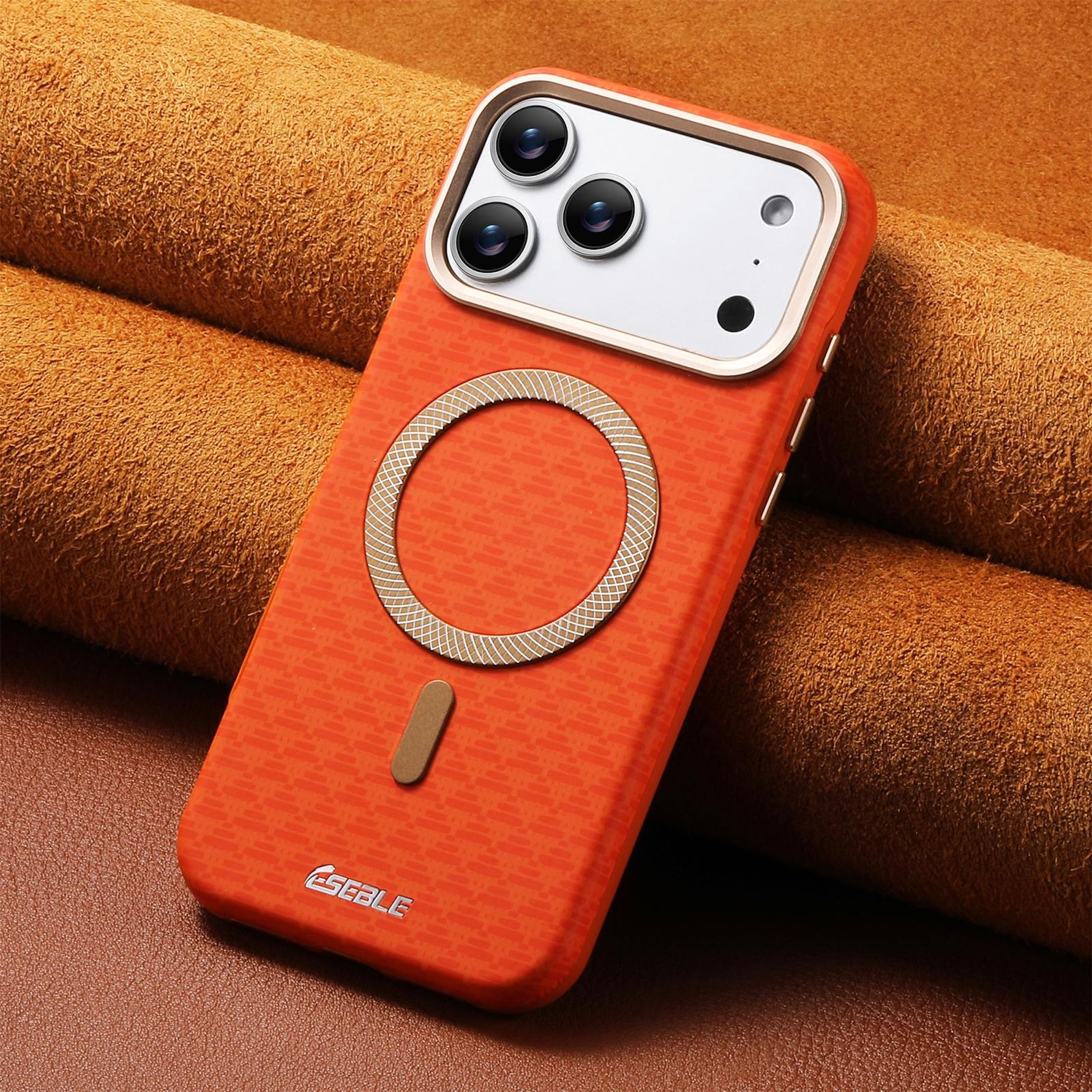 Orange Handyhülle mit Kameramodul und Magnetring auf braunem Leder.