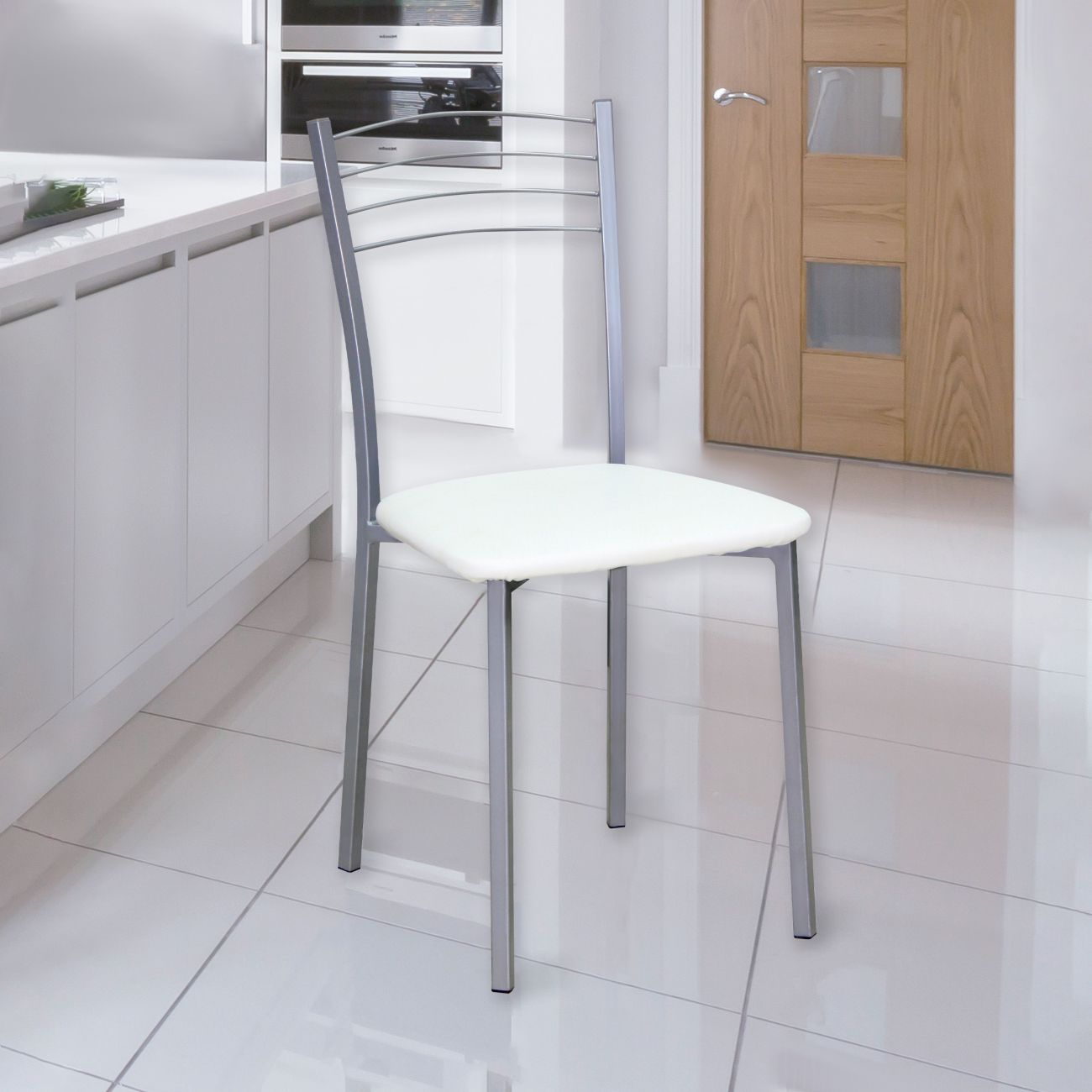 Una silla blanca con marco de metal se encuentra en una cocina moderna con gabinetes blancos.
