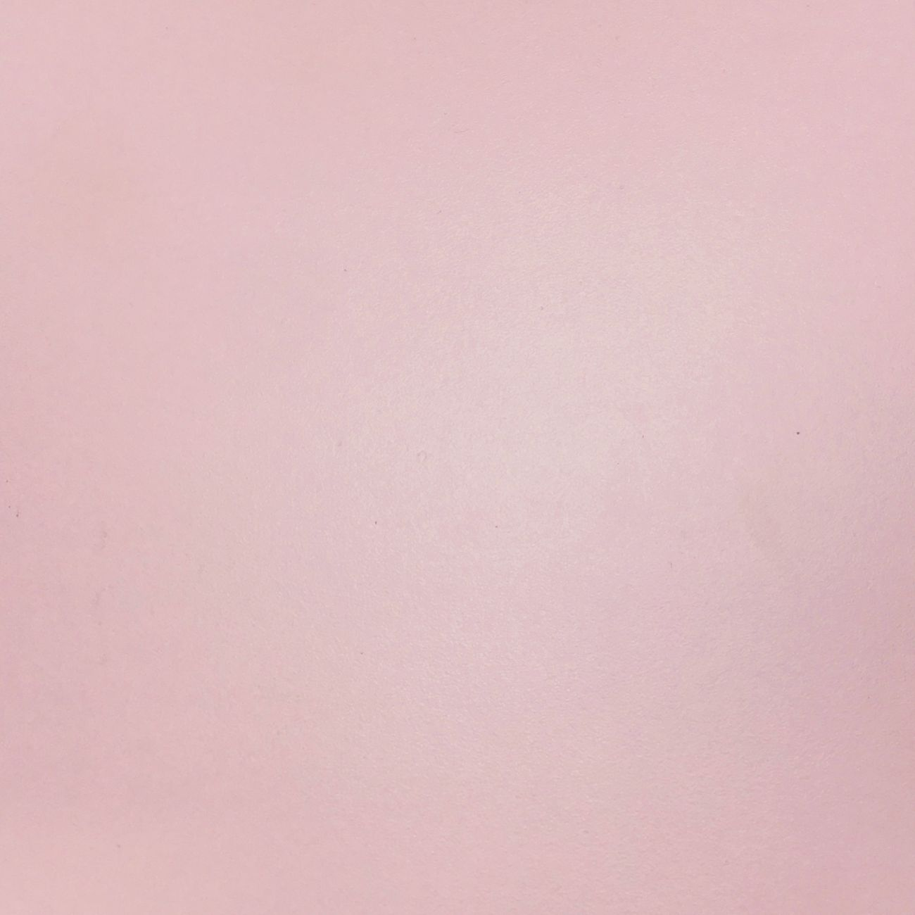 Una superficie lisa, plana y de color rosa claro con sombras sutiles.