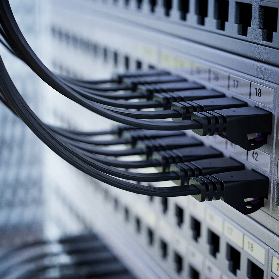 Czarne kable podłączone do szafy portów sieciowych.