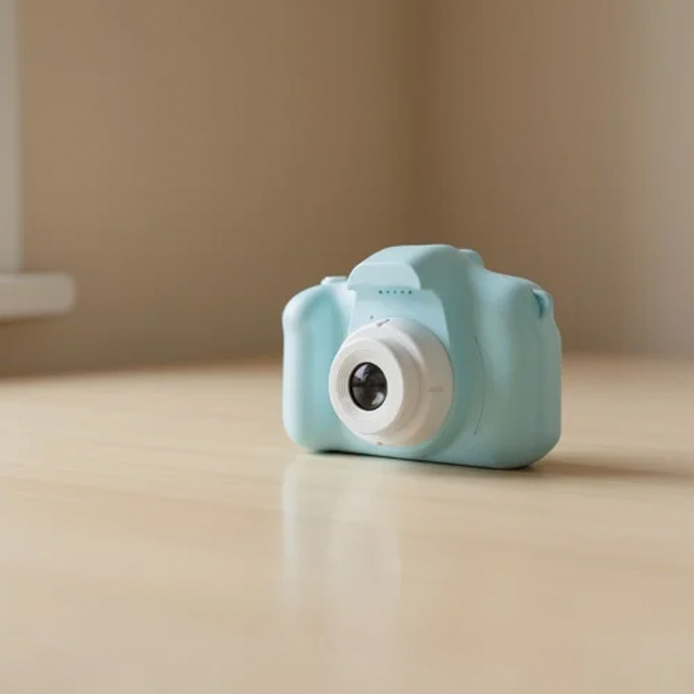 Beyaz lens halkalı açık mavi dijital kamera ahşap bir masanın üzerinde duruyor.